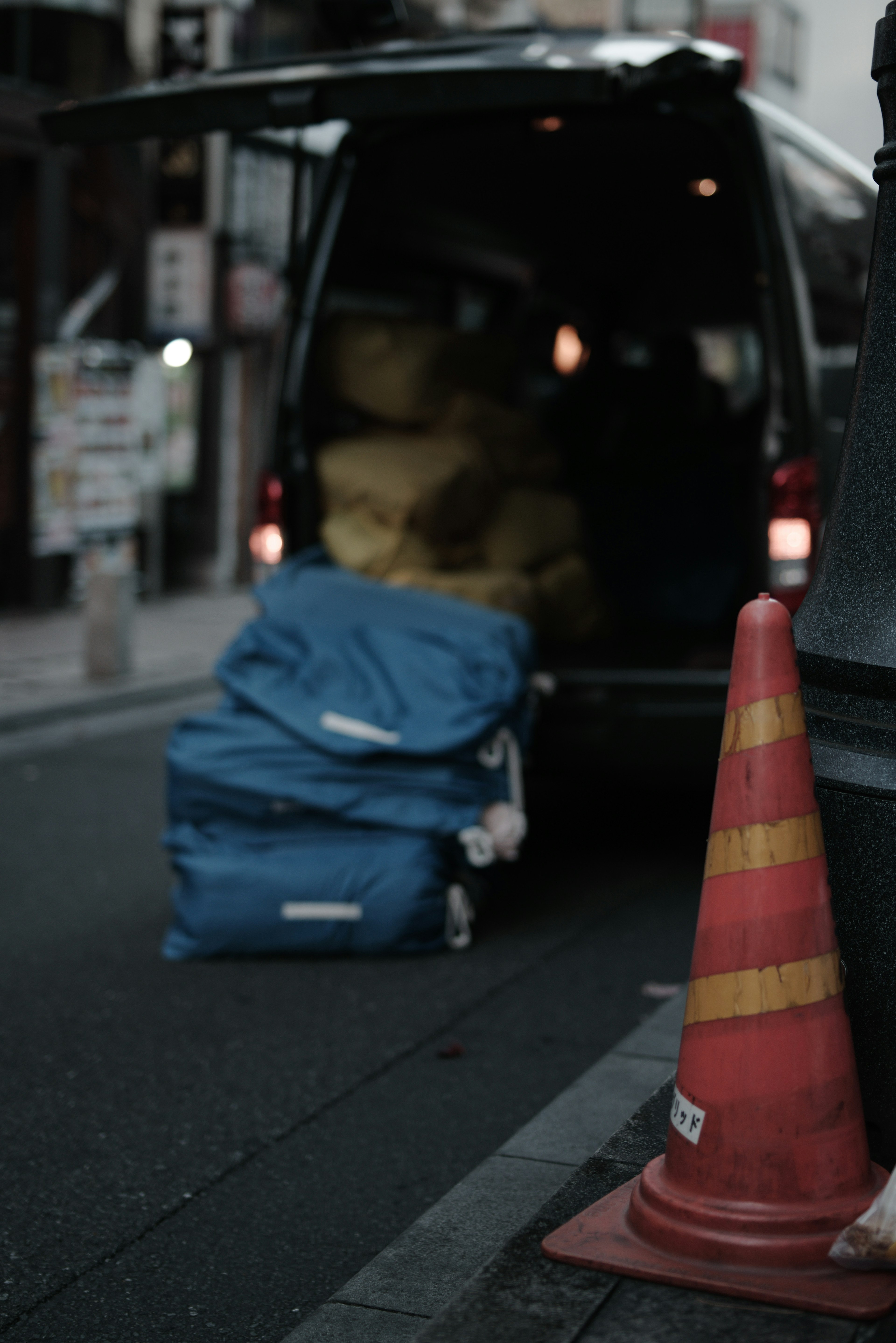 Street scene with blue bags and a traffic cone