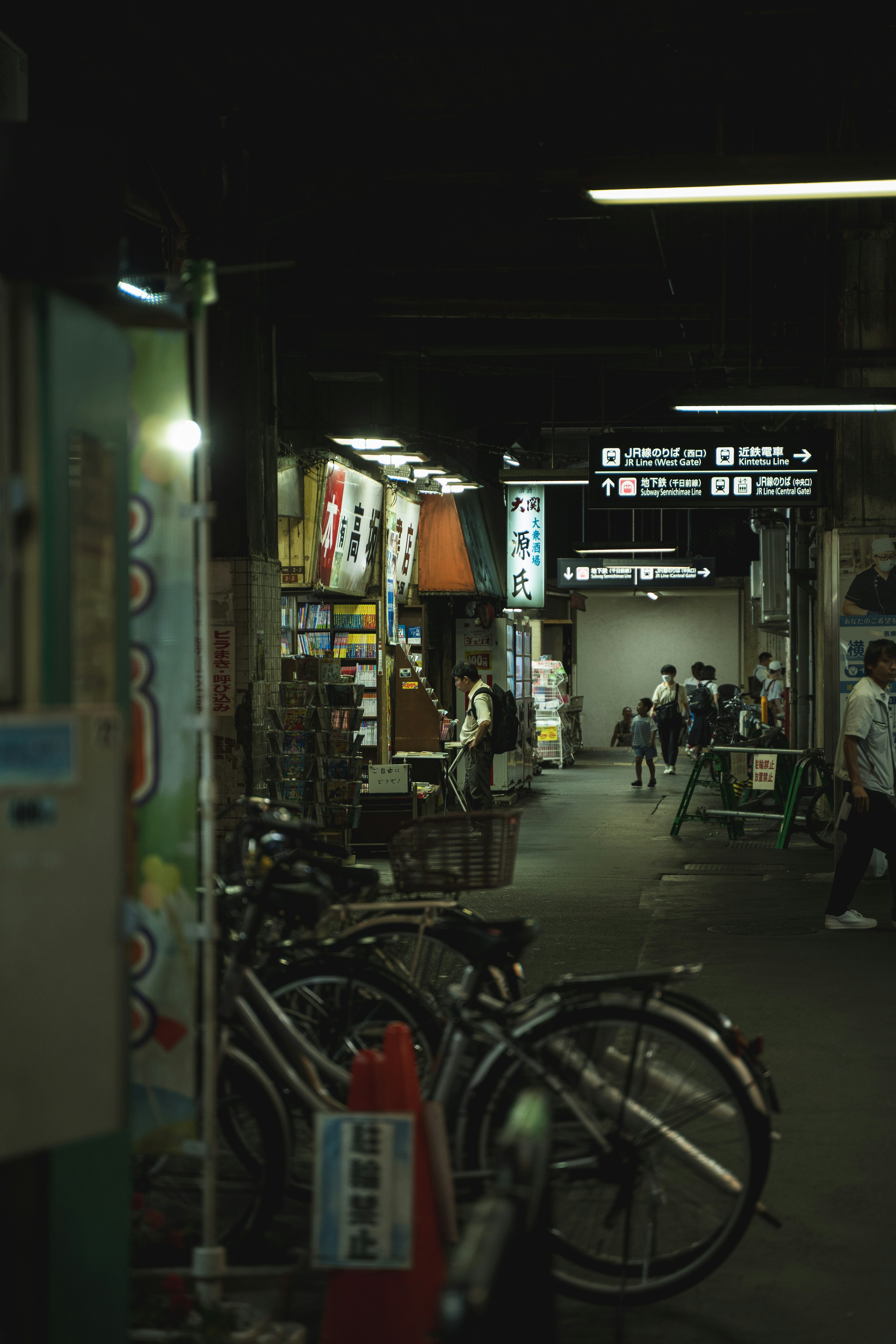 Lorong redup dengan sepeda dan papan nama toko