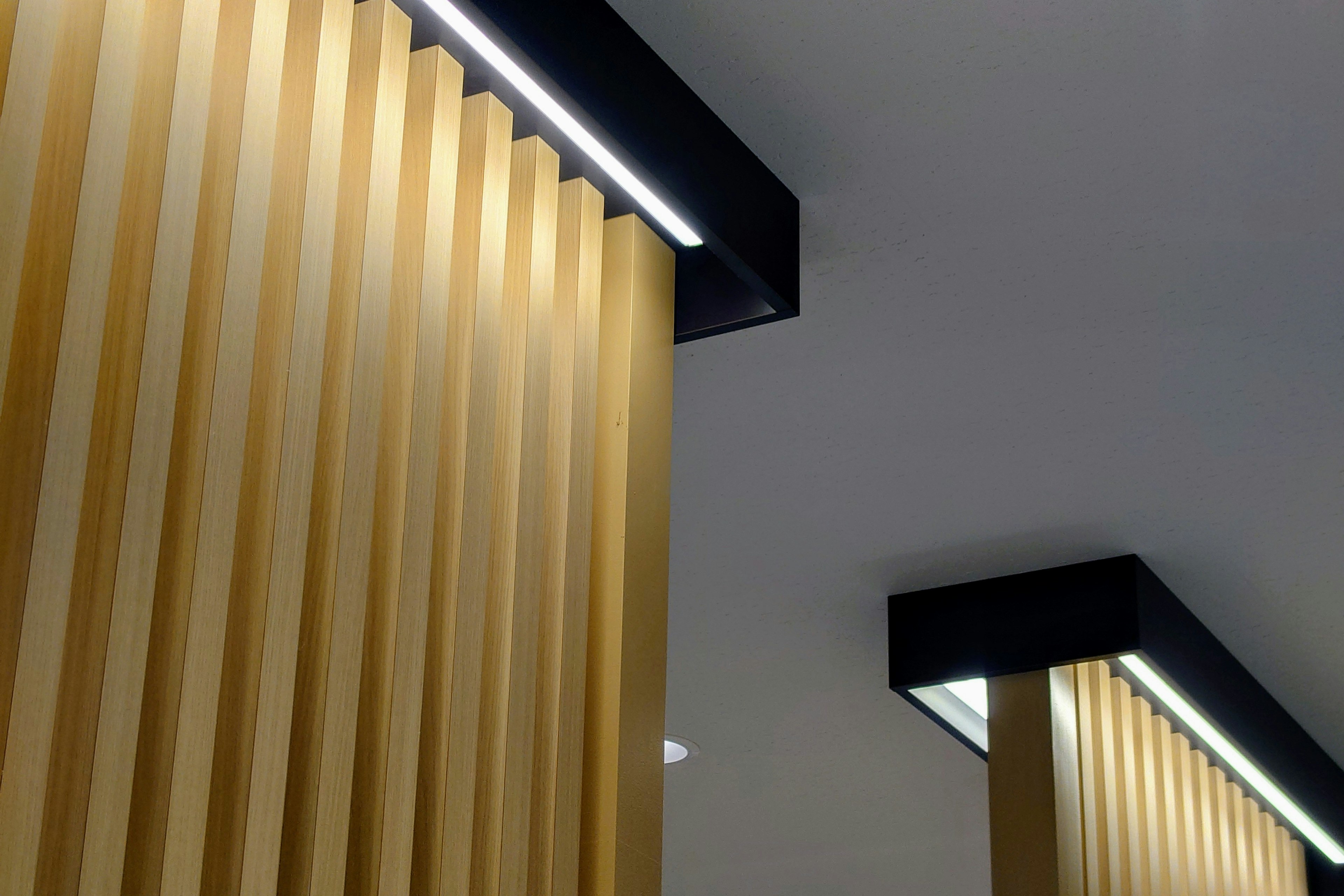 Modern interior featuring golden vertical slats and black lighting