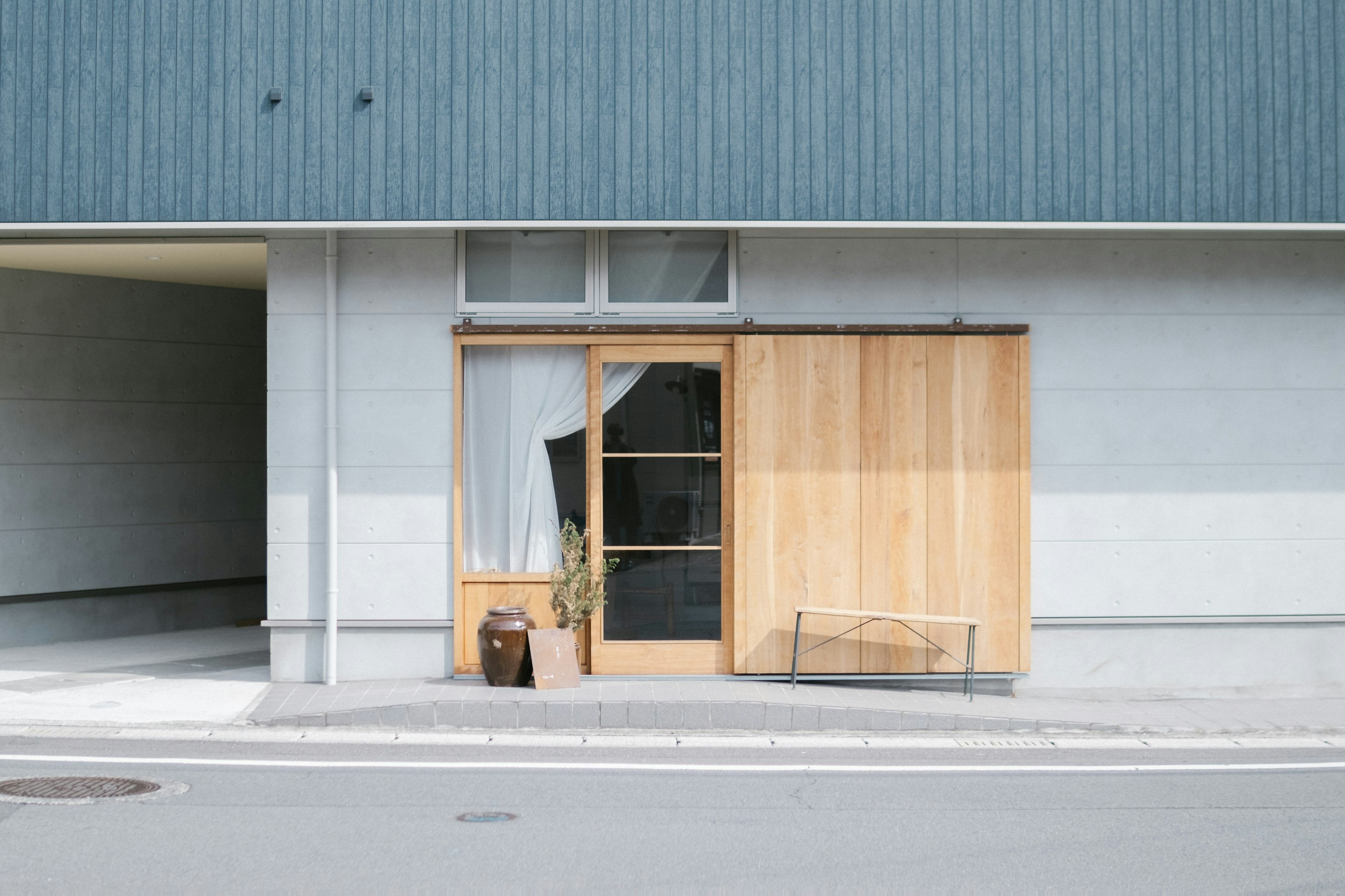 Modern building facade featuring wooden door and large window