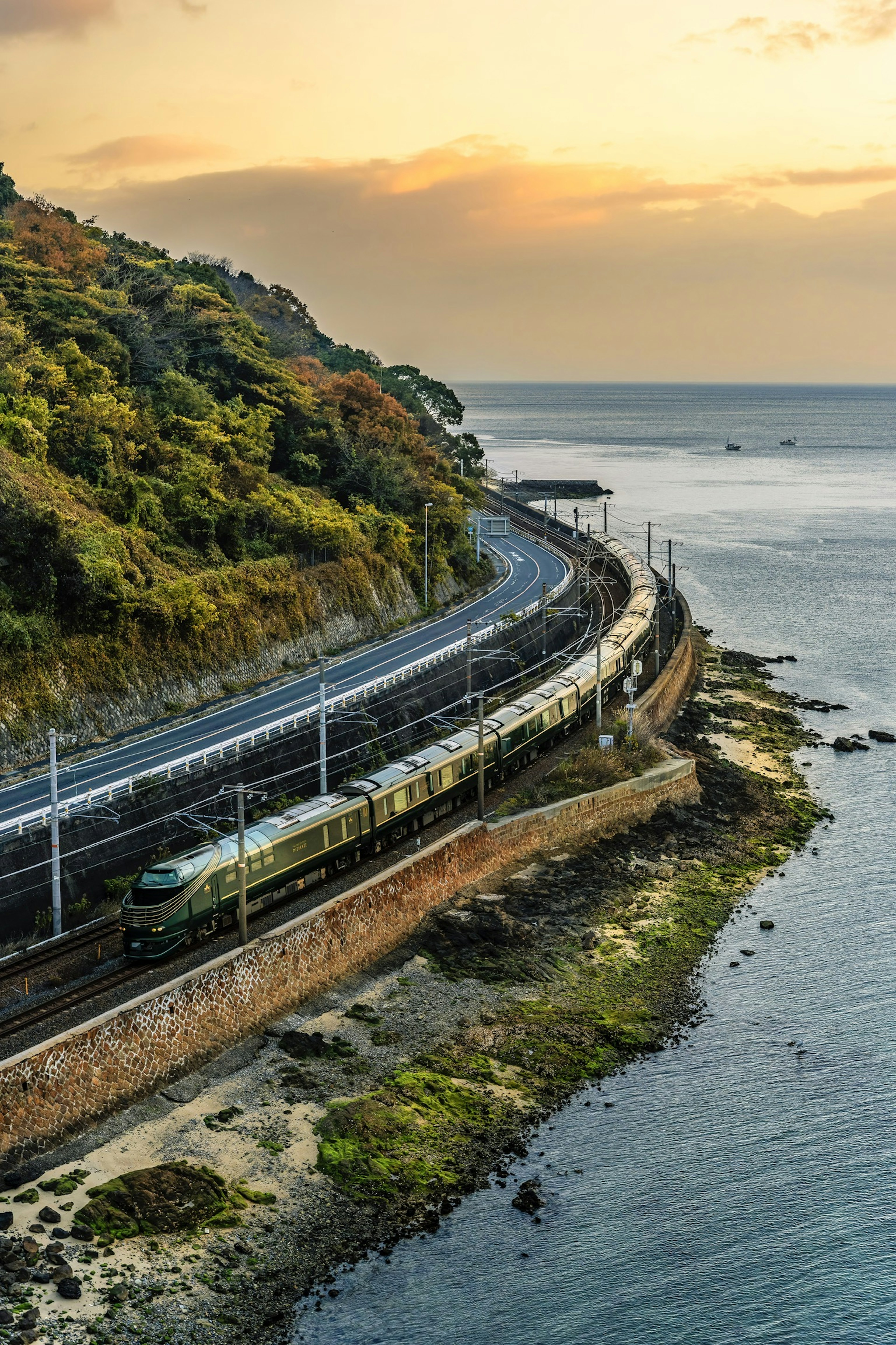 Tren que corre a lo largo de la costa con un hermoso atardecer