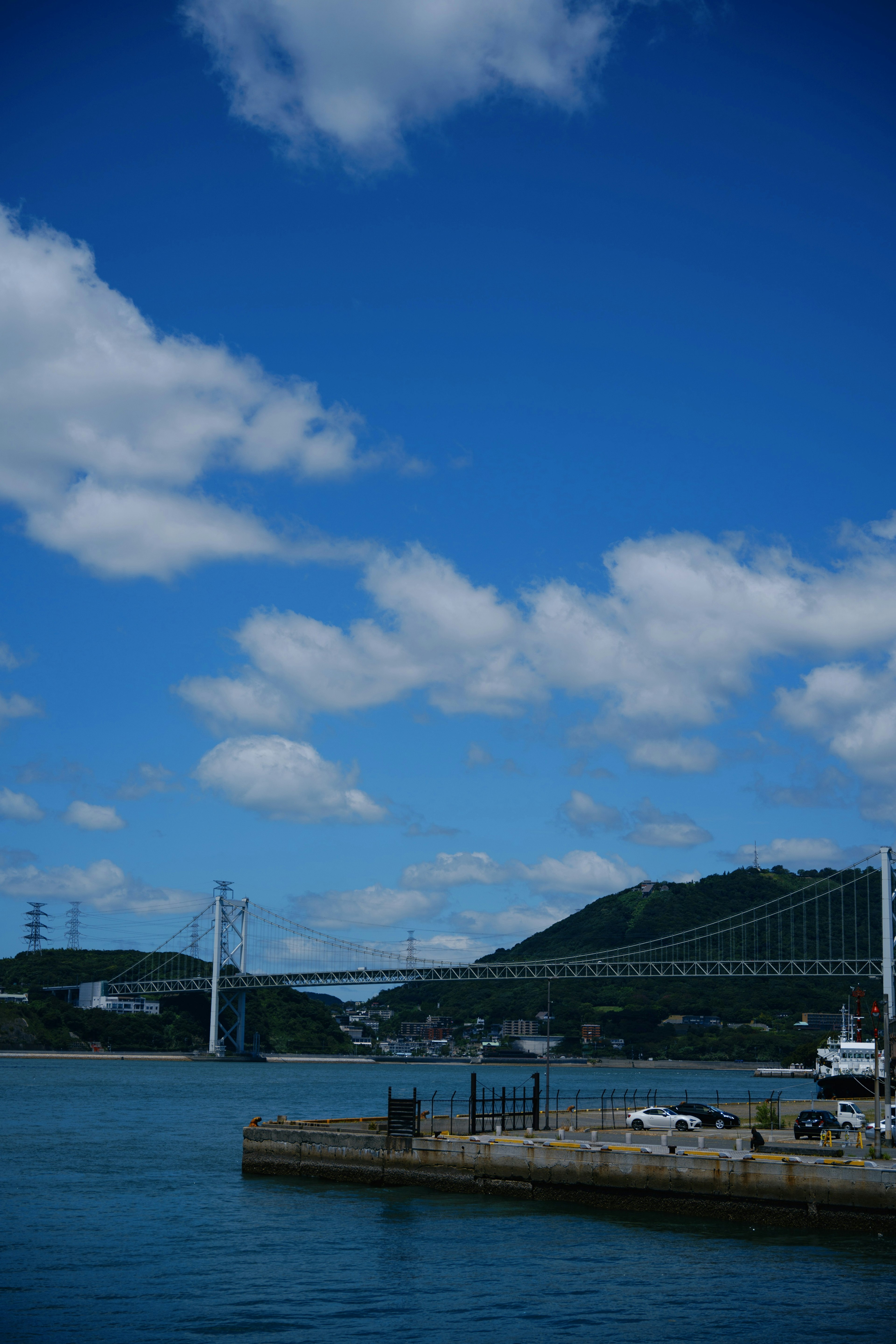 青い空と白い雲の下にある橋と港の風景