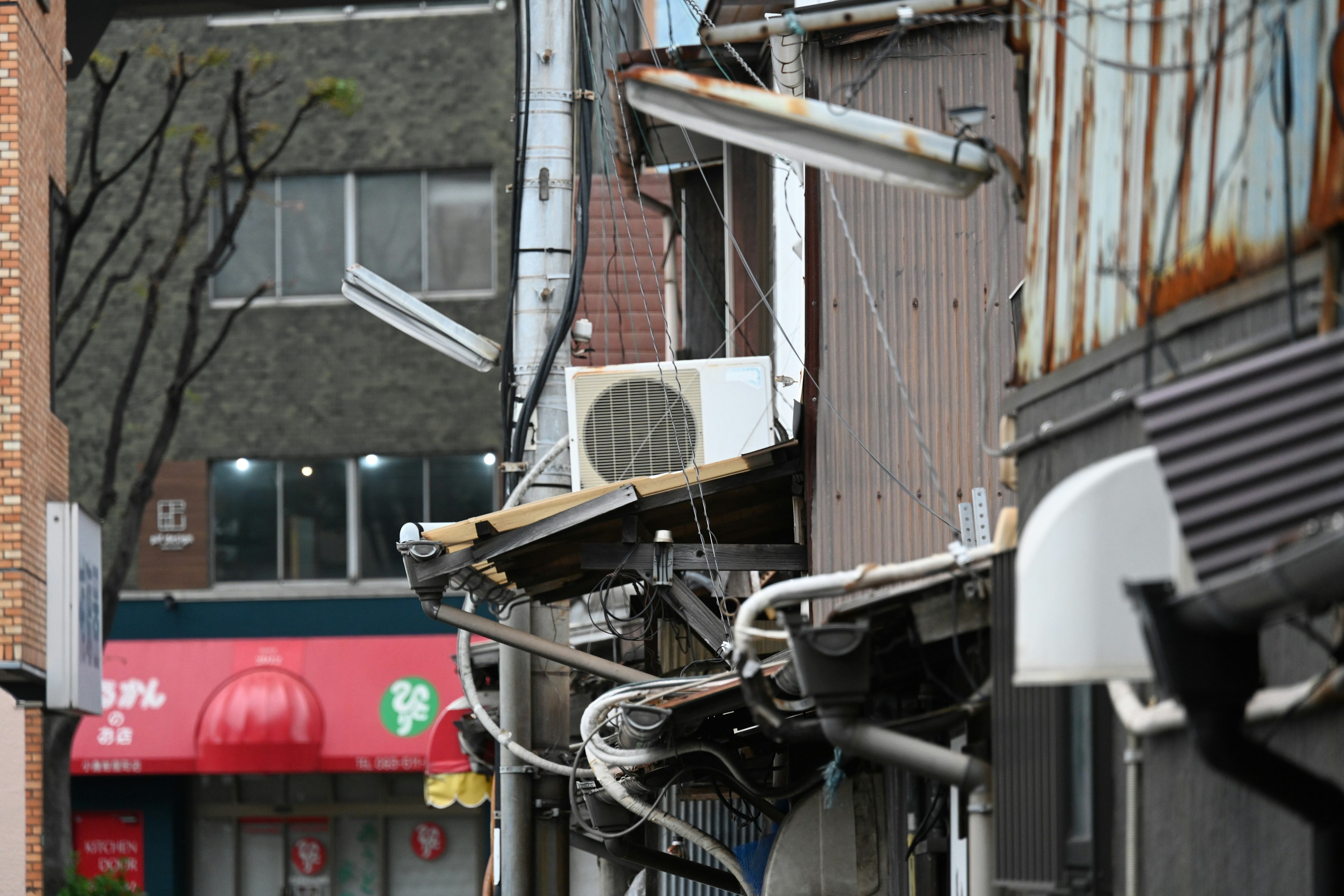 Urban scene featuring old building exterior with air conditioning units and pipes