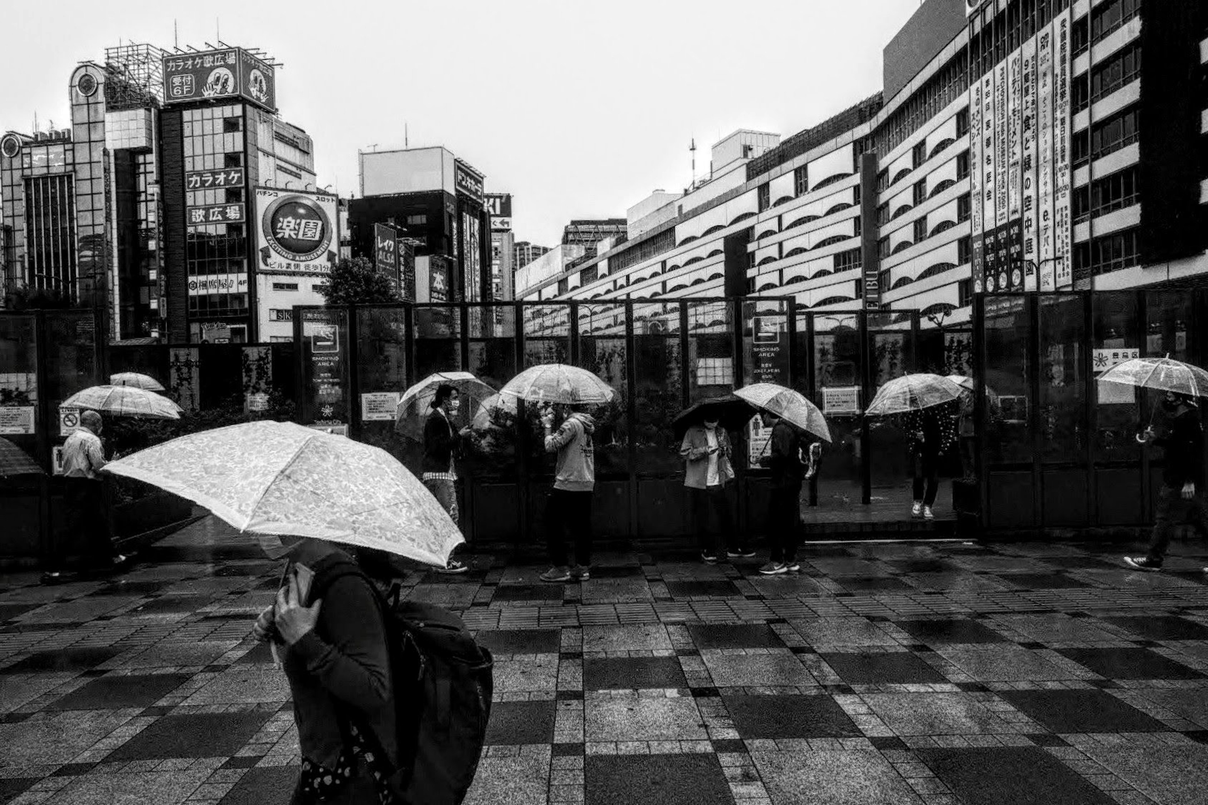 雨の中で傘を持つ人々が歩く都市の風景