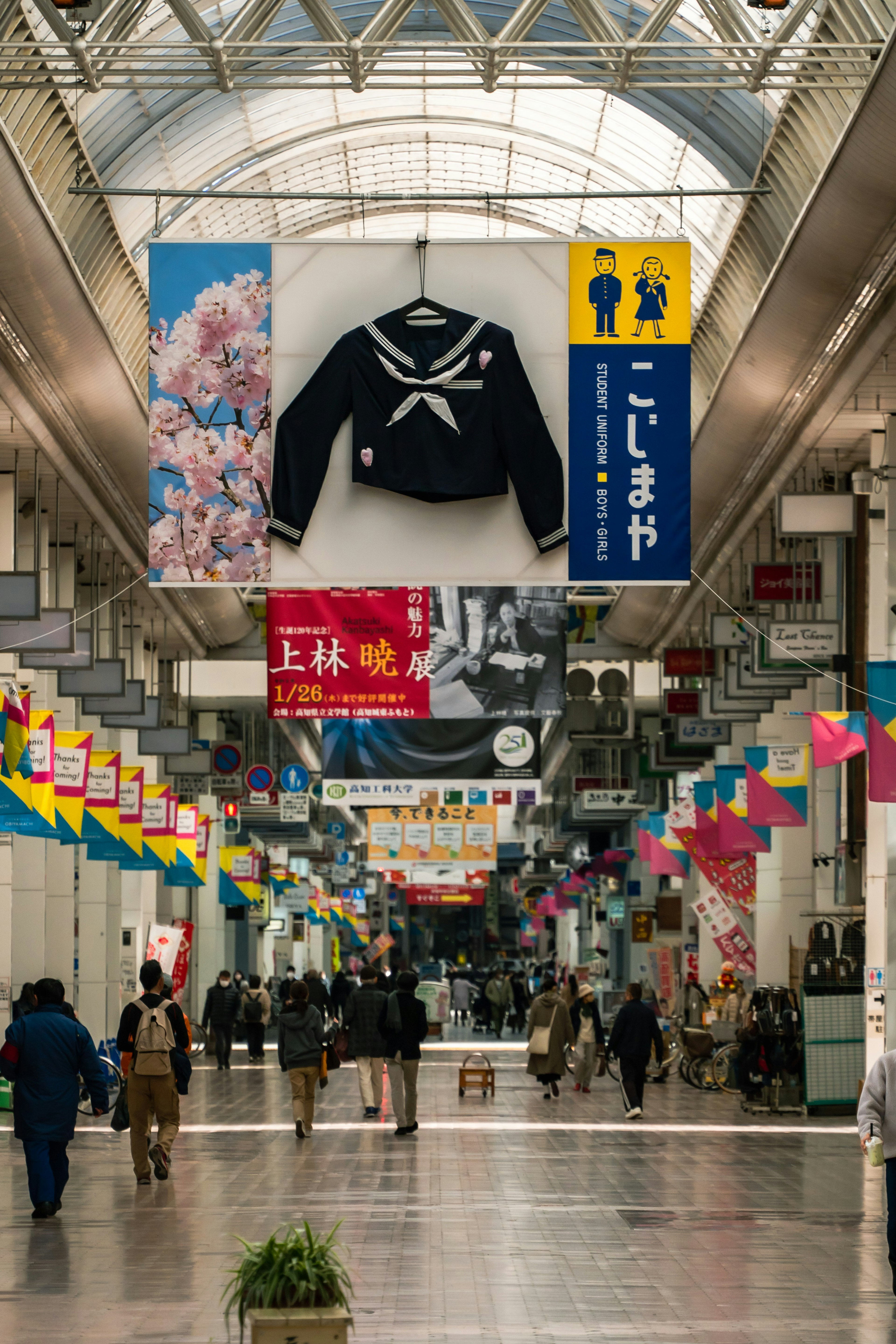 Arcade commerciale avec un uniforme de marin suspendu et des décorations colorées