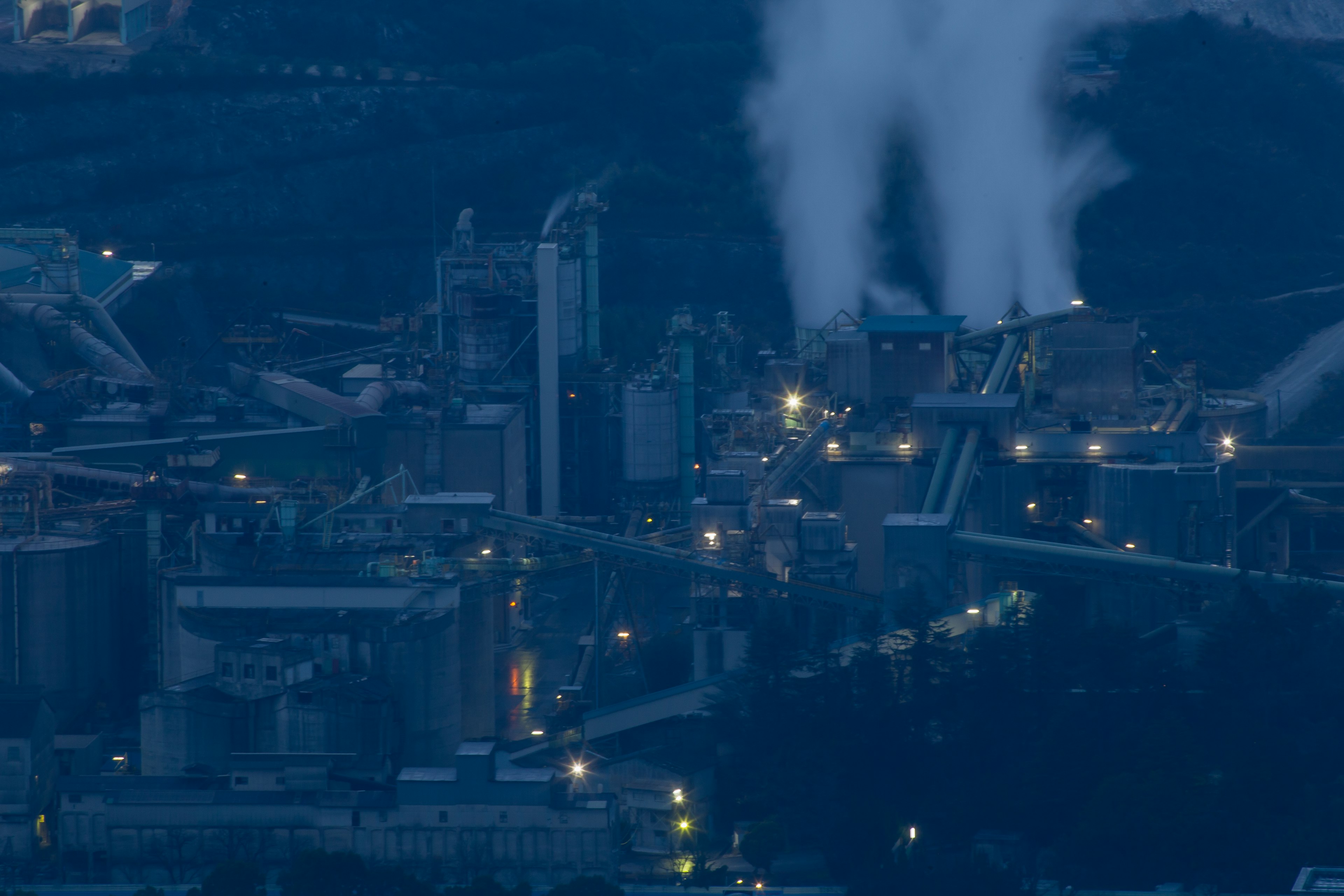 Night view of industrial facility with smoke stacks