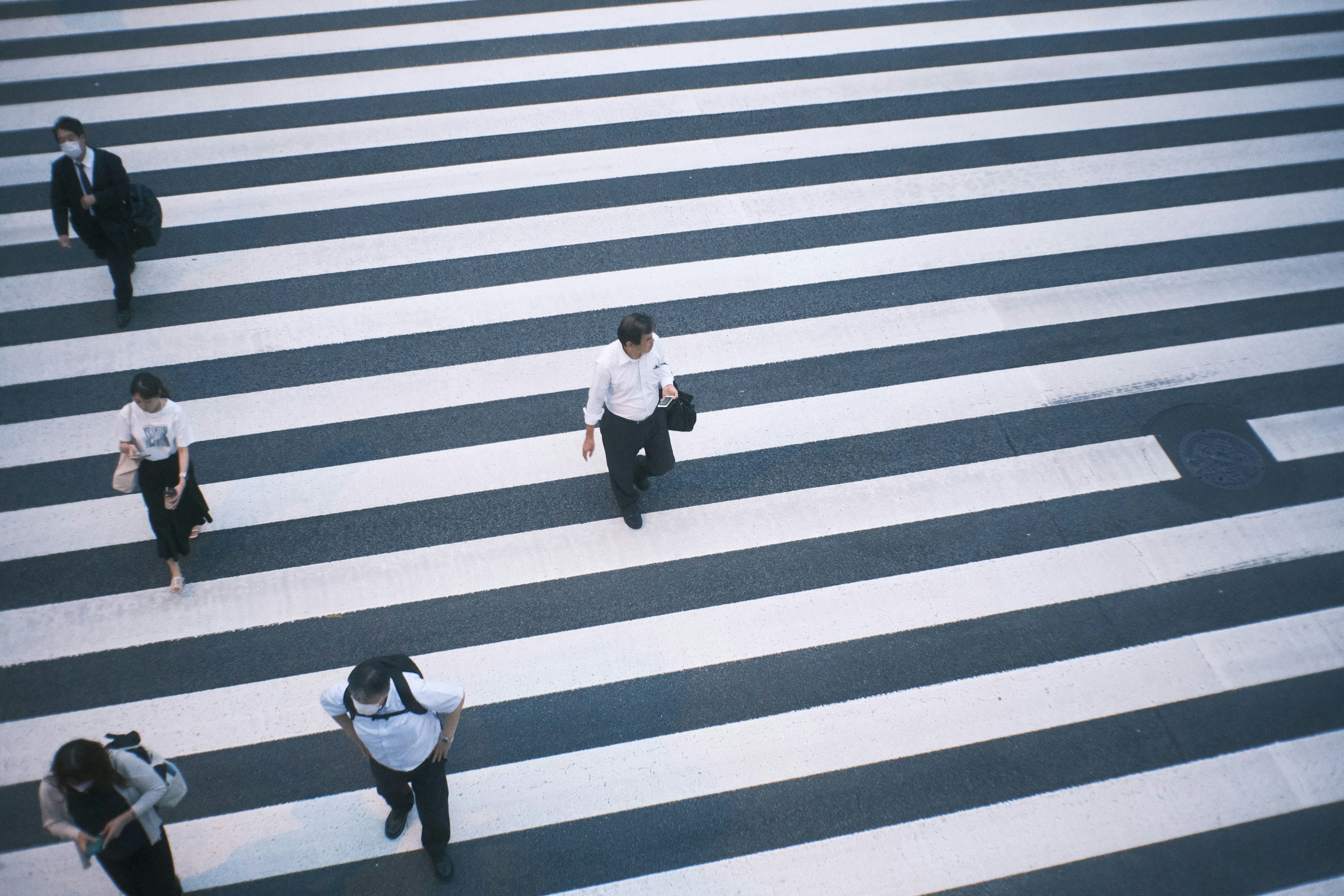 Pandangan dari atas orang-orang yang berjalan di atas zebra cross hitam dan putih