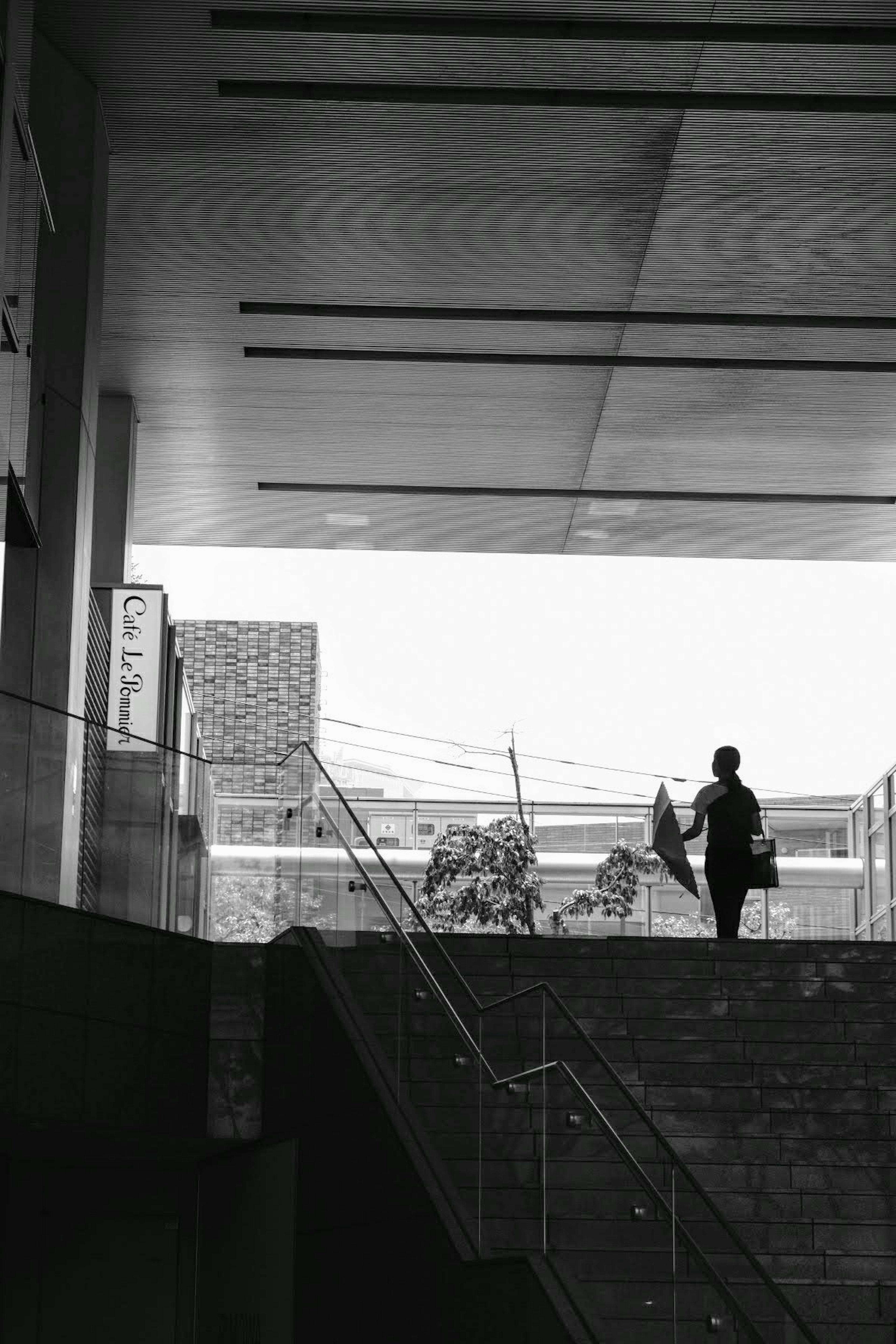 Silhouette einer Person mit einem Regenschirm, die Treppen hinuntergeht