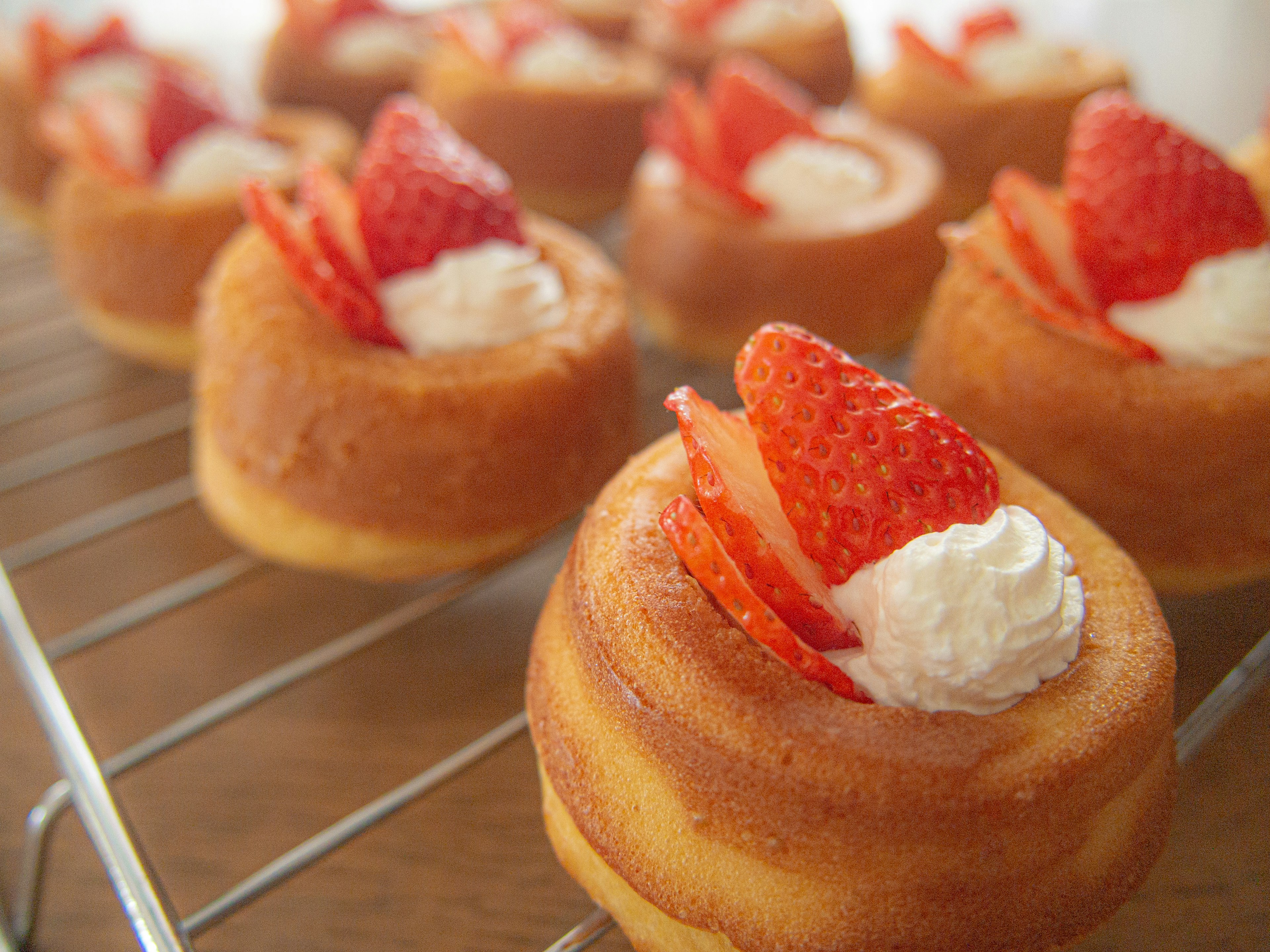 Mini dessert alle fragole disposti su una griglia di raffreddamento