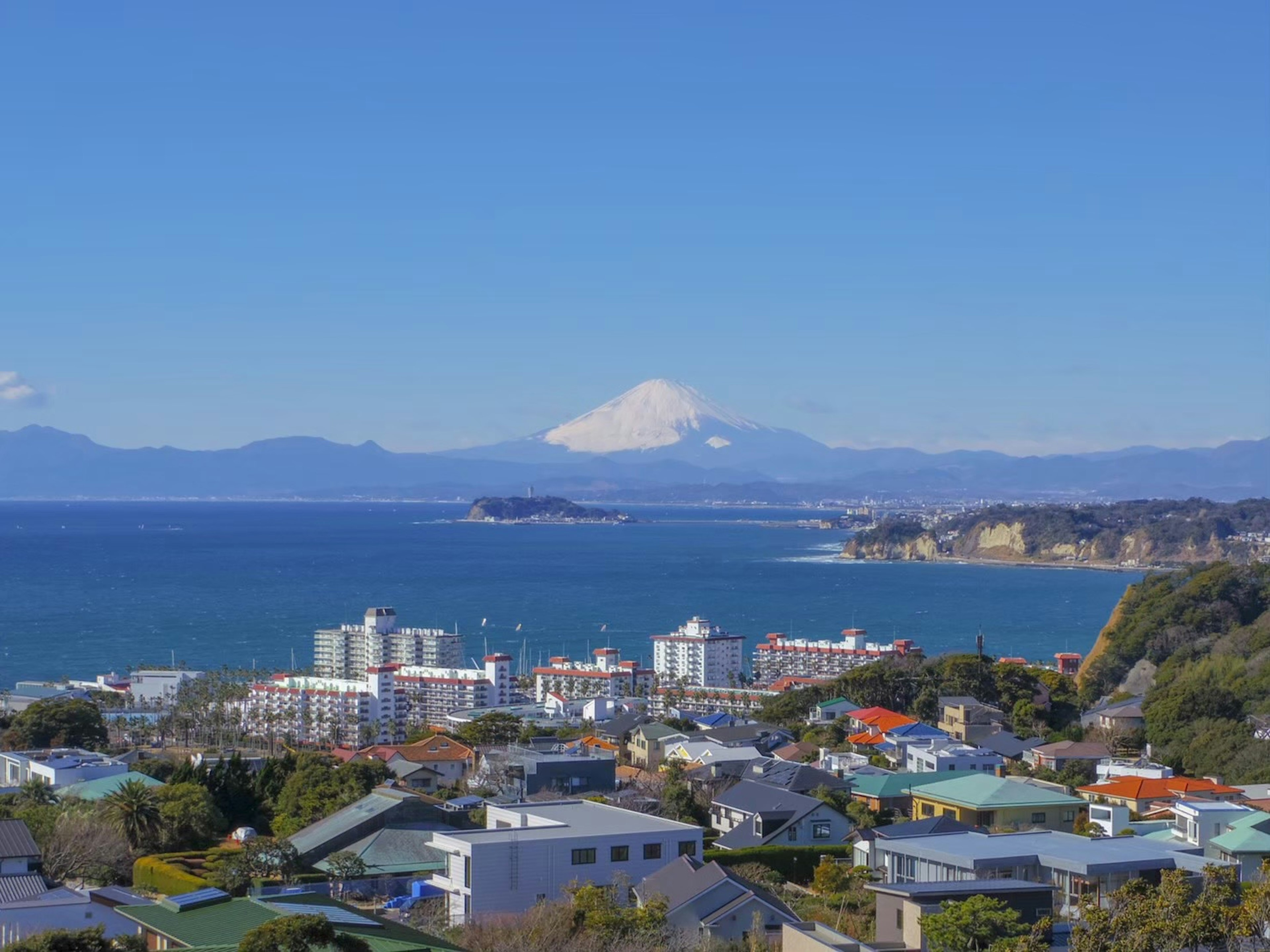 Scenic view of the ocean and mountains with Mount Fuji in the distance