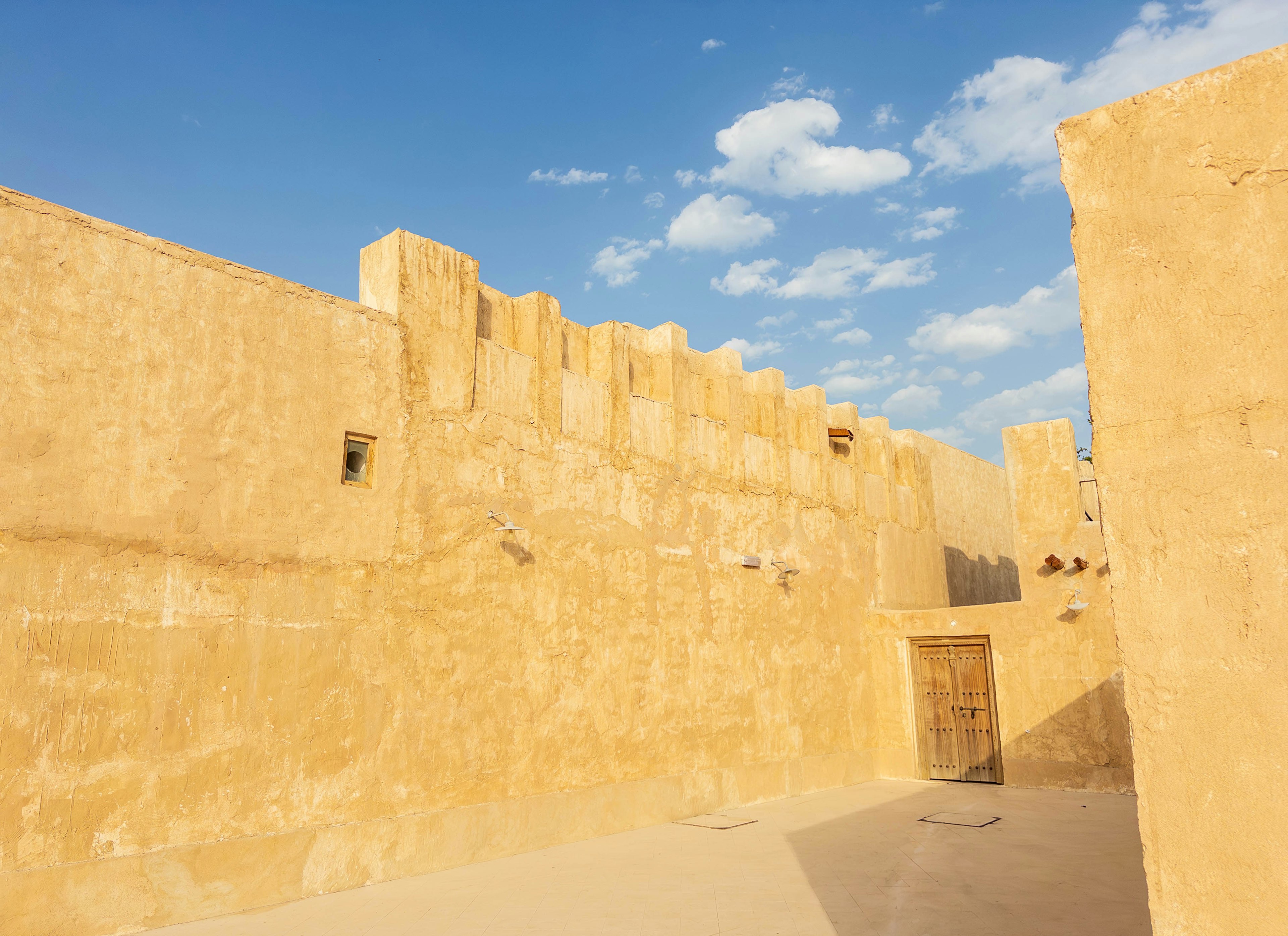 Interior view of a desert fortress with yellow walls and blue sky