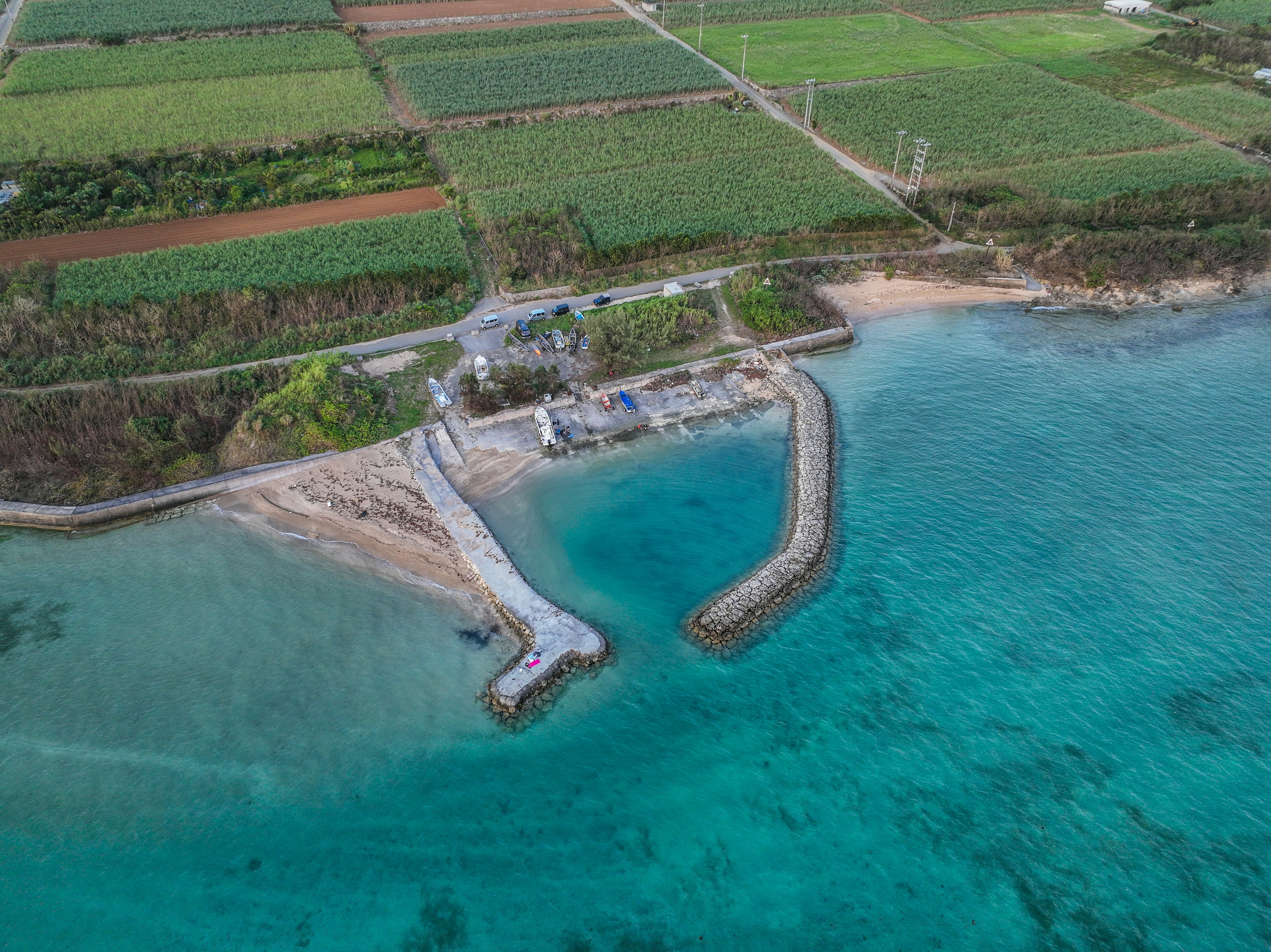 Aerial view of a harbor surrounded by water and green fields