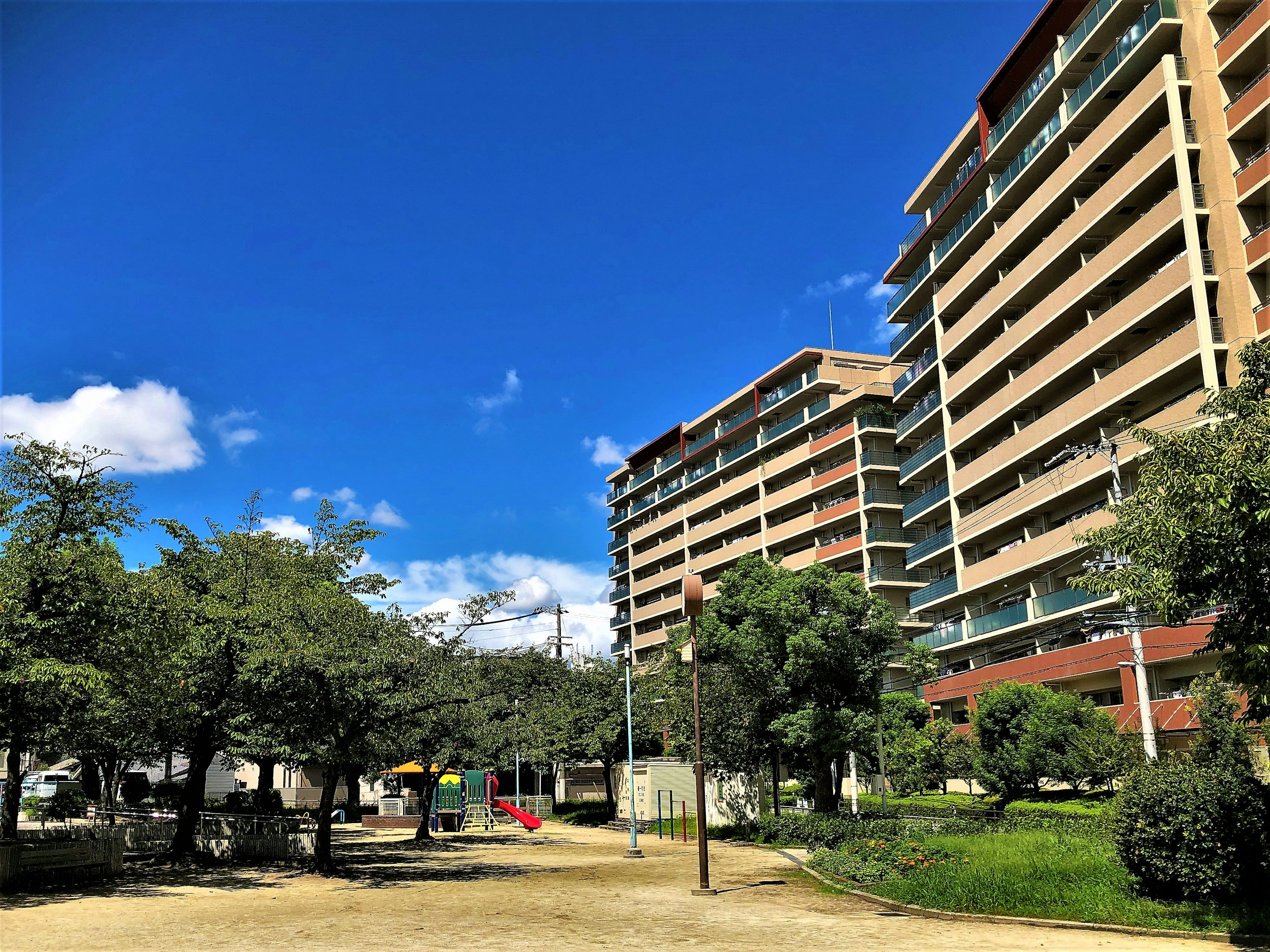 Edifici residenziali alti sotto un cielo azzurro e un parco