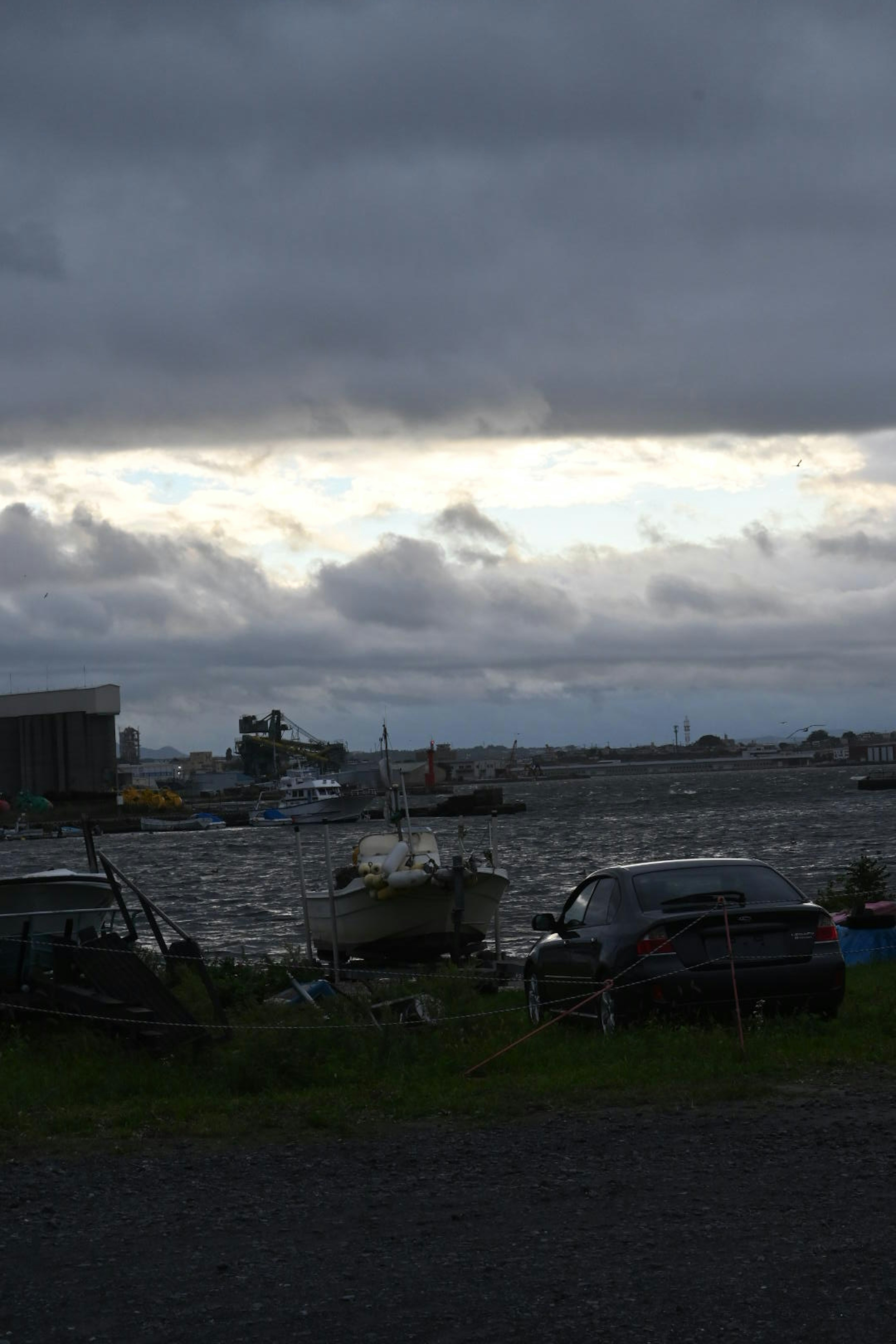 暗い雲に覆われた海とボートが見える風景