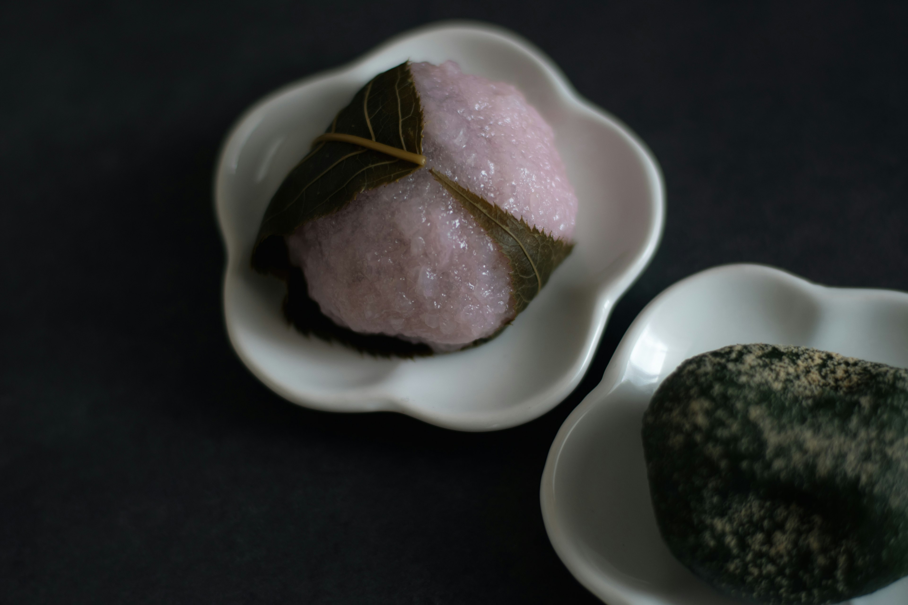 Sakura-Mochi und Kusa-Mochi auf weißen Tellern präsentiert