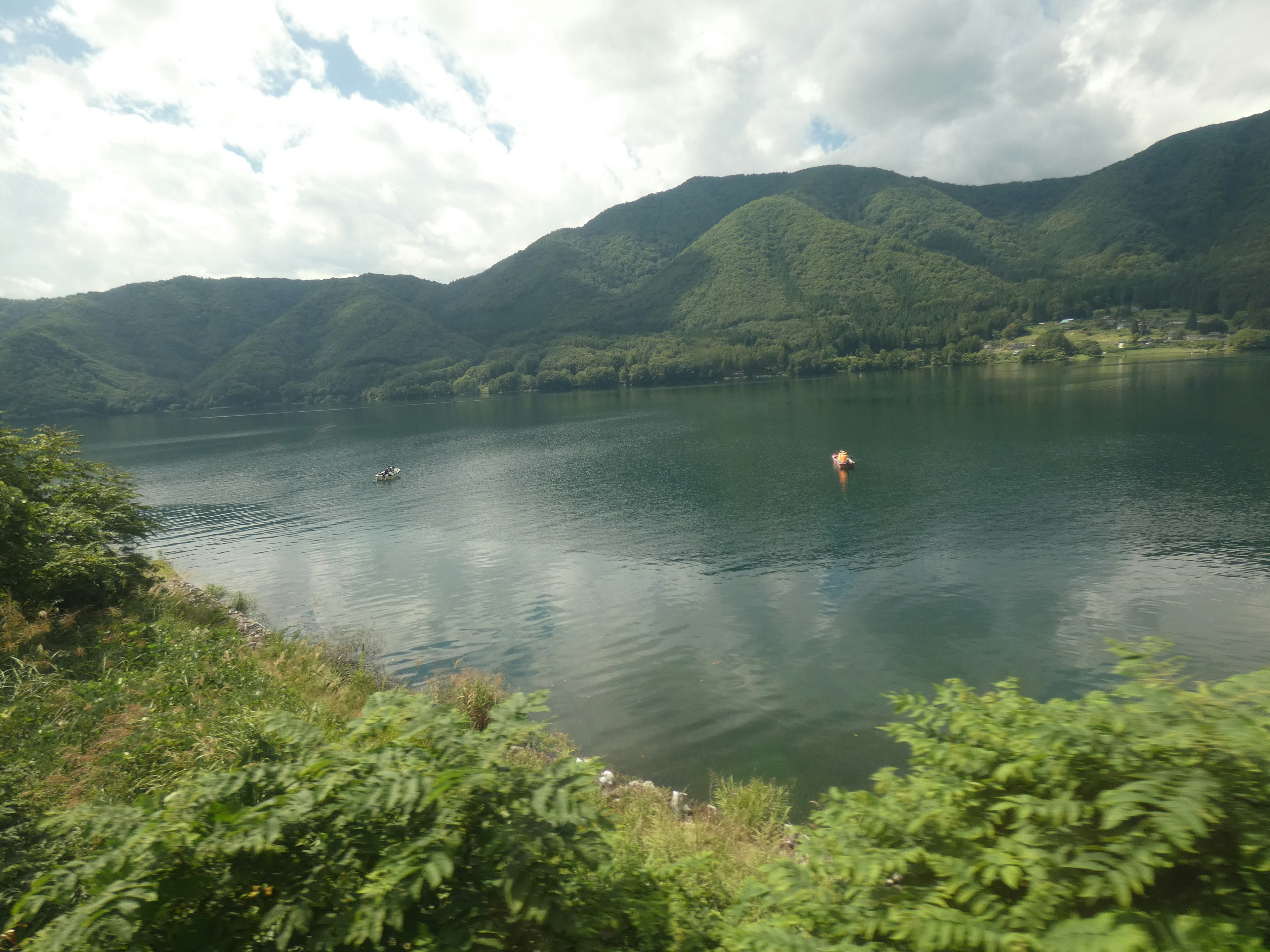 Lago sereno con montagne verdeggianti sullo sfondo