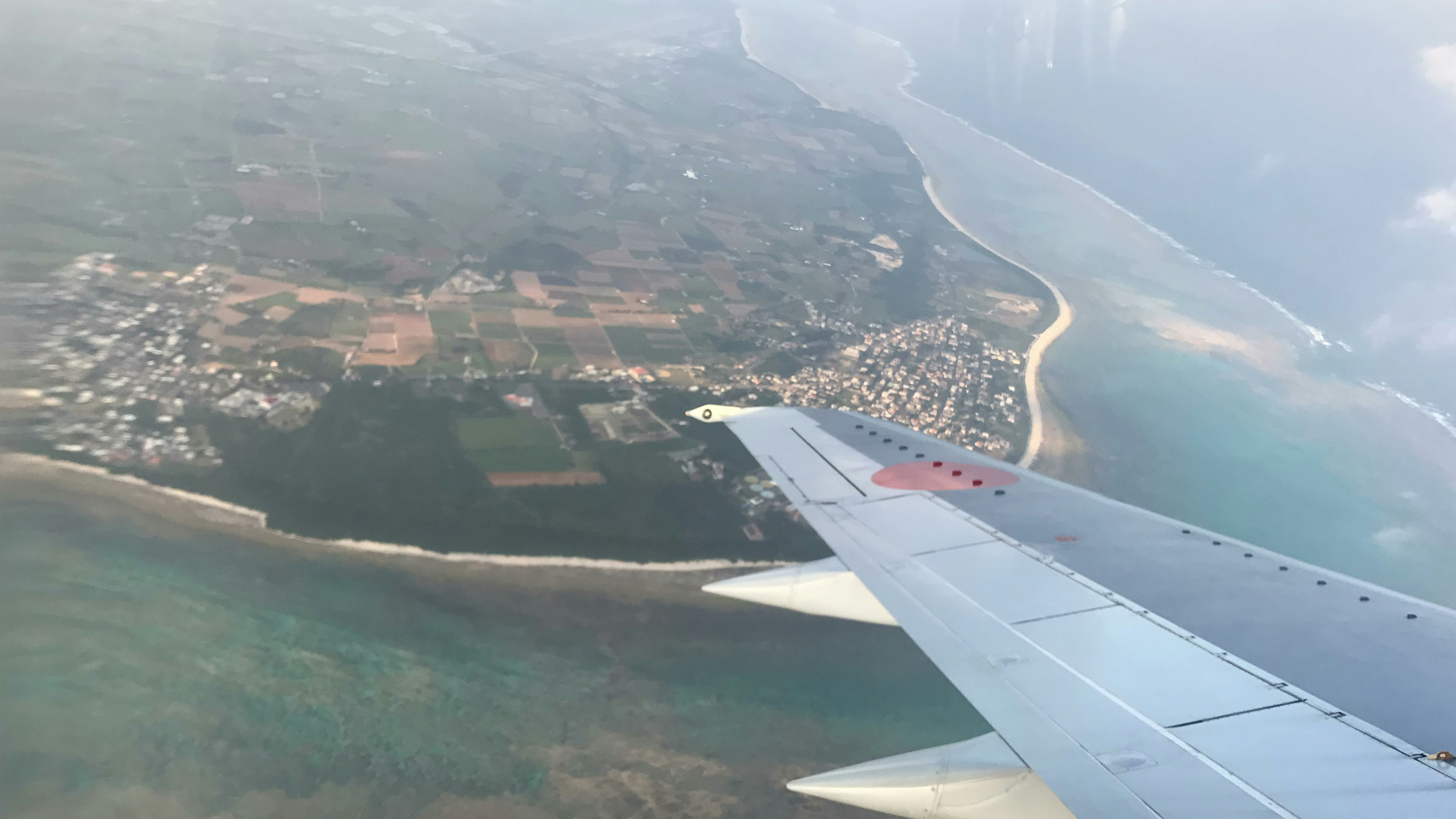 Aerial view featuring an airplane wing and coastal landscape