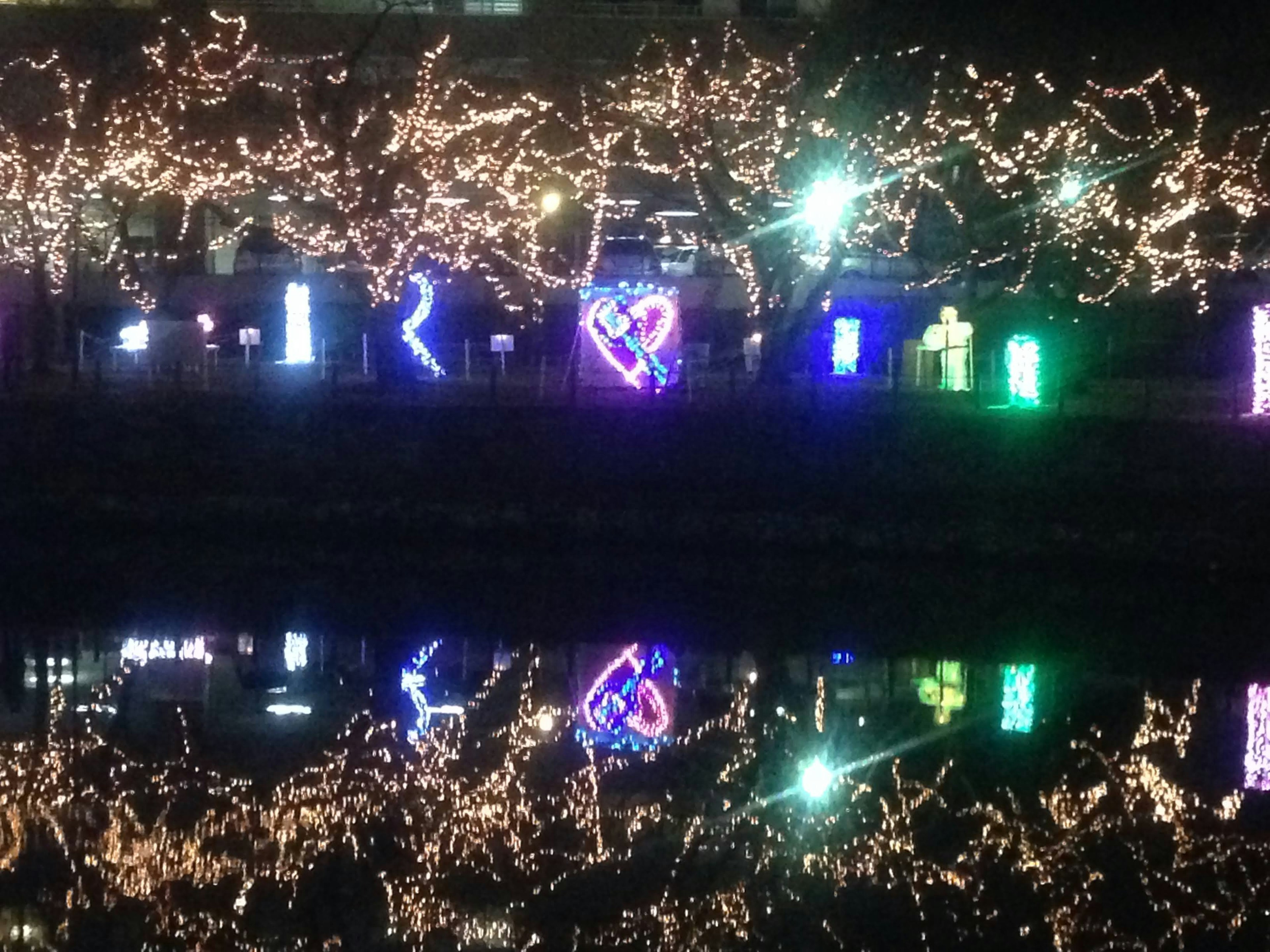 Bunte Lichtshow, die sich nachts auf einem Fluss spiegelt