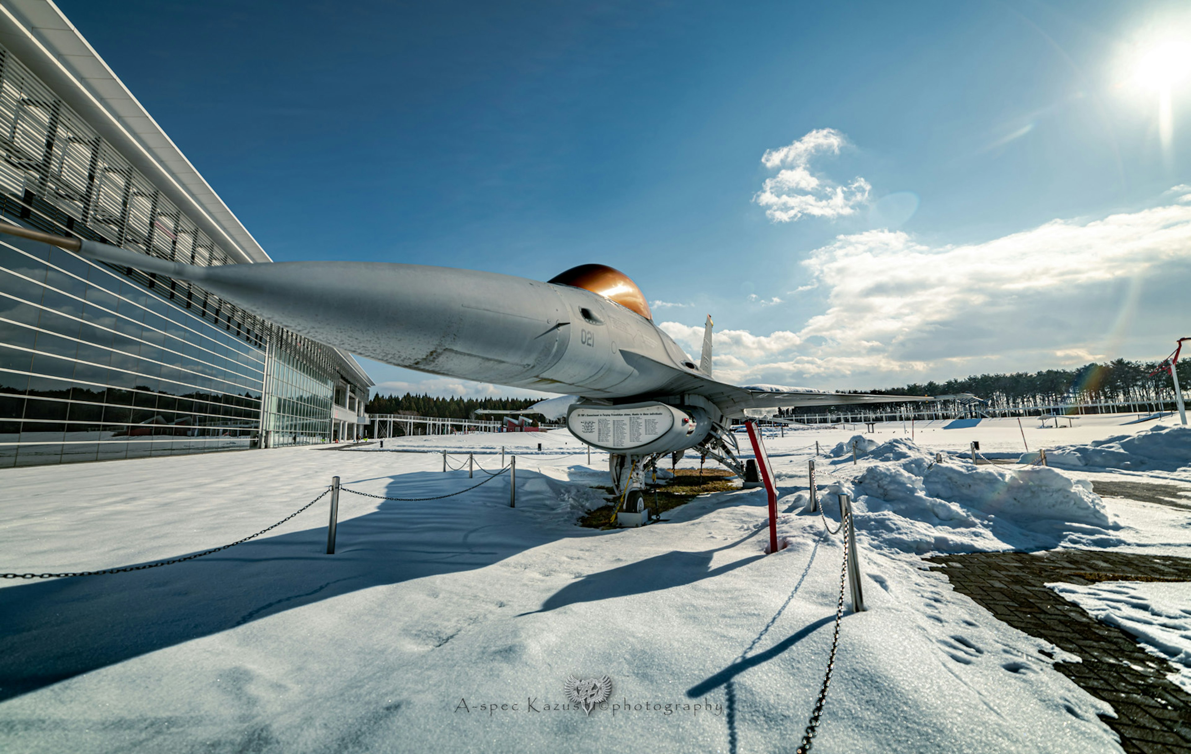 Close-up of an aircraft on snow with a clear blue sky and clouds