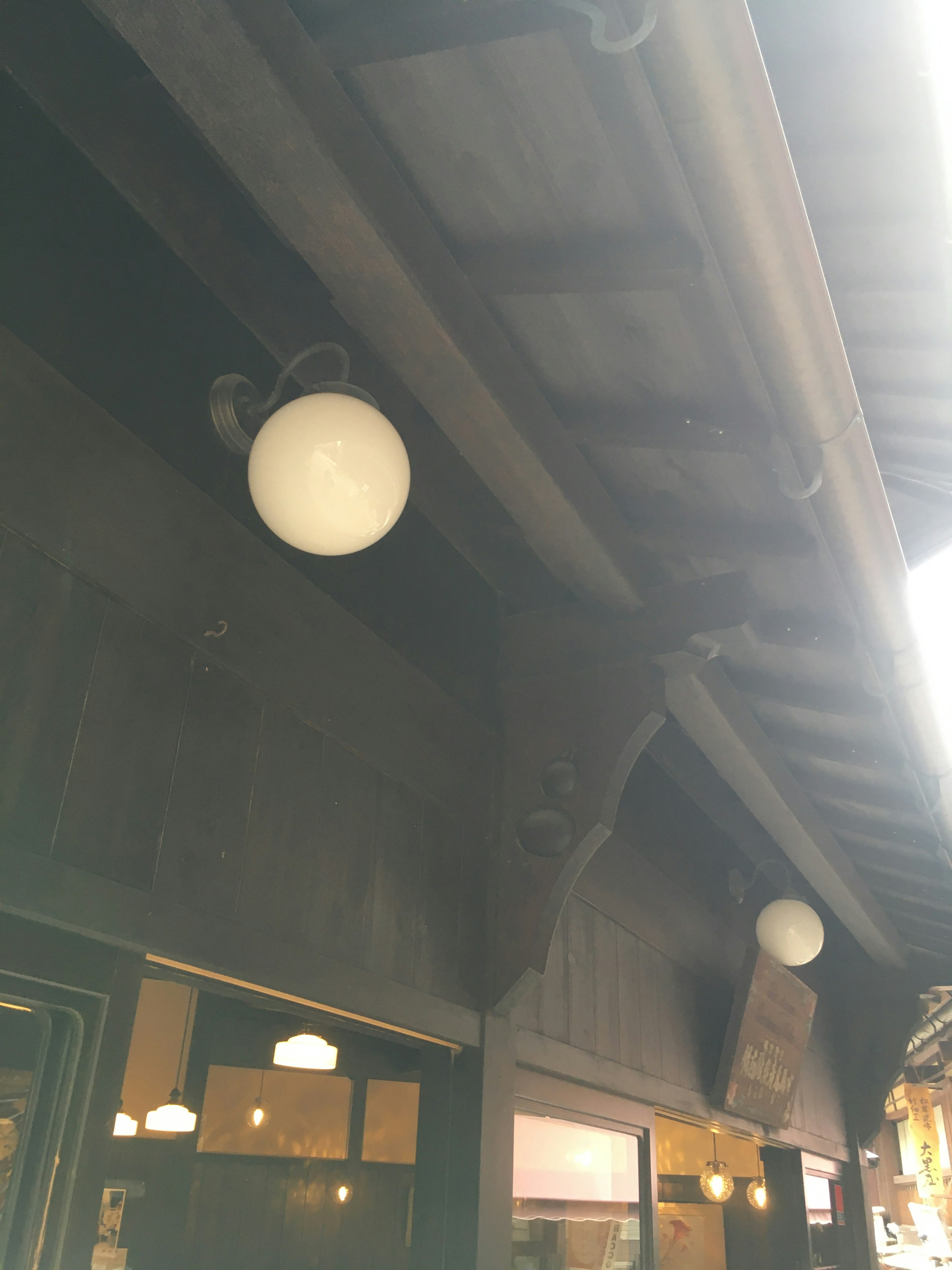 Exterior of a traditional building featuring wooden ceiling and white lighting