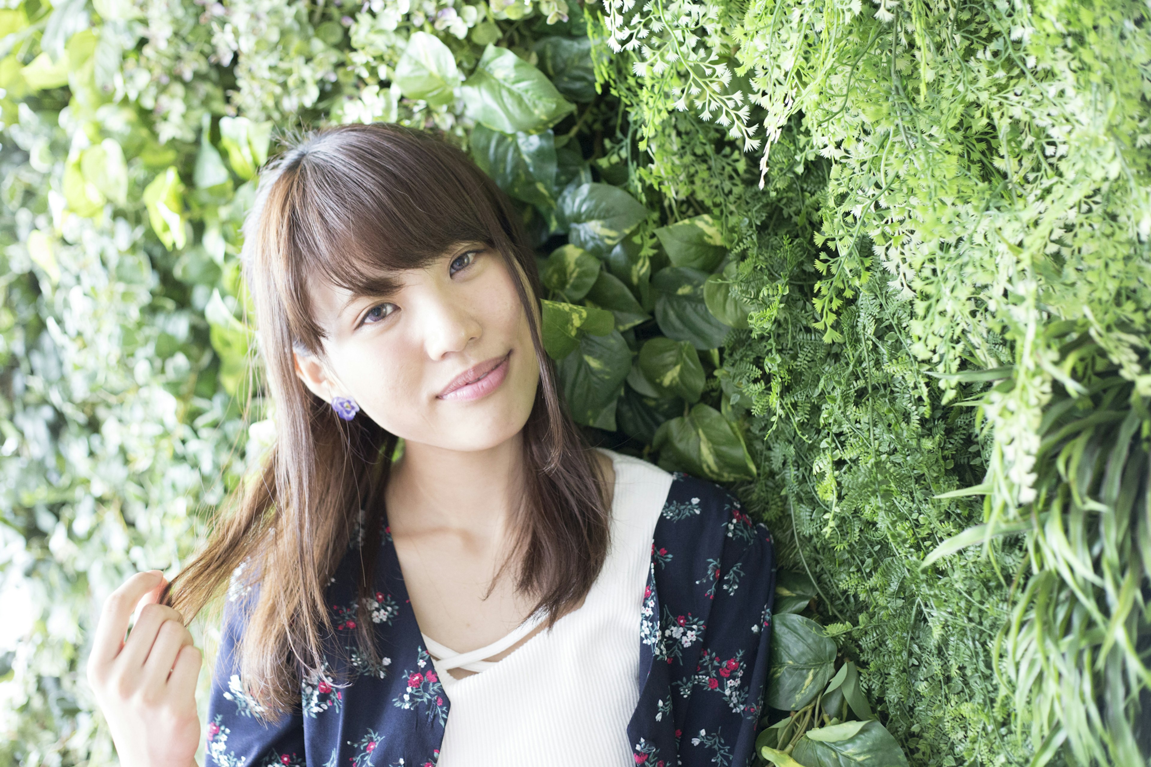 Portrait of a woman smiling in front of a green wall