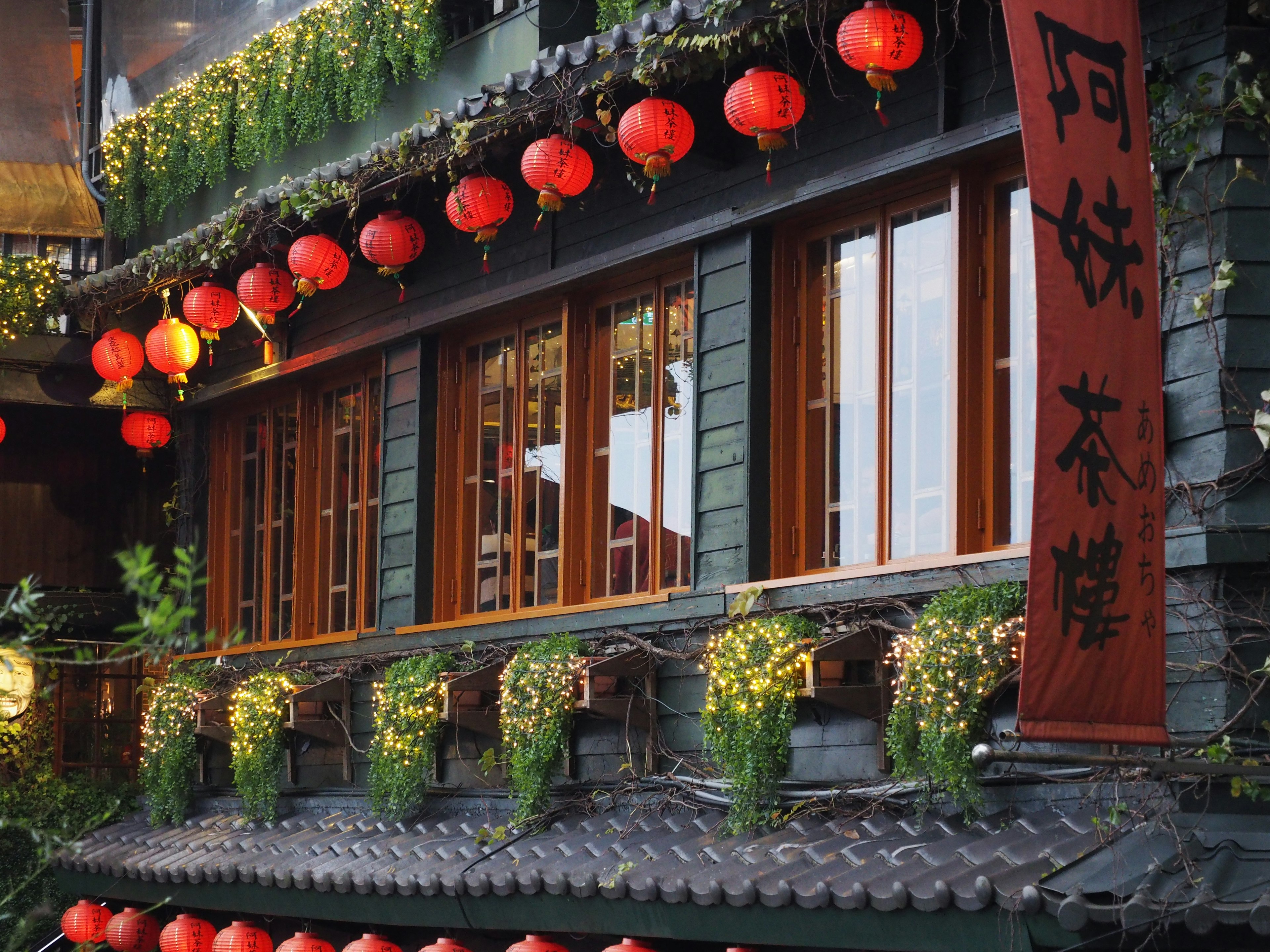 Bâtiment traditionnel chinois avec des lanternes rouges et des fenêtres en bois