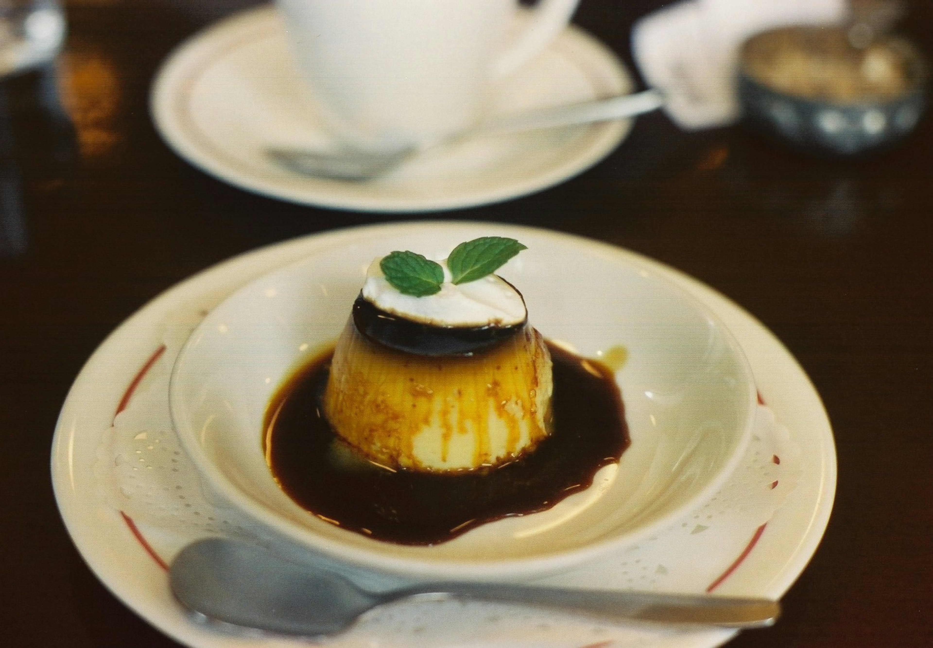 Puding karamel dengan krim dan daun mint di atasnya