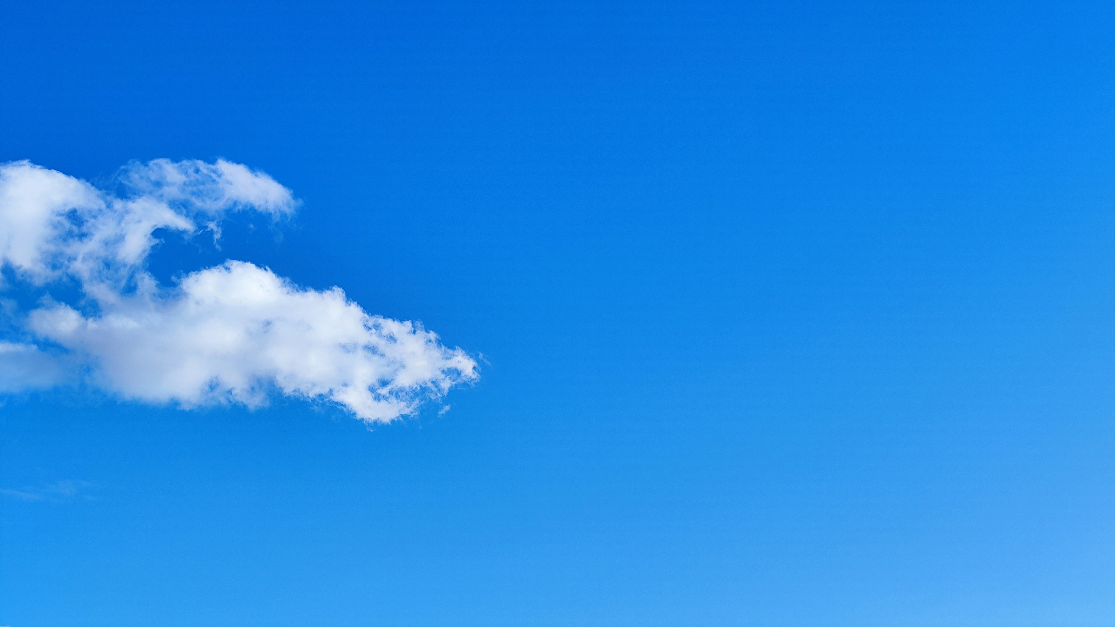 A clear blue sky with a white cloud