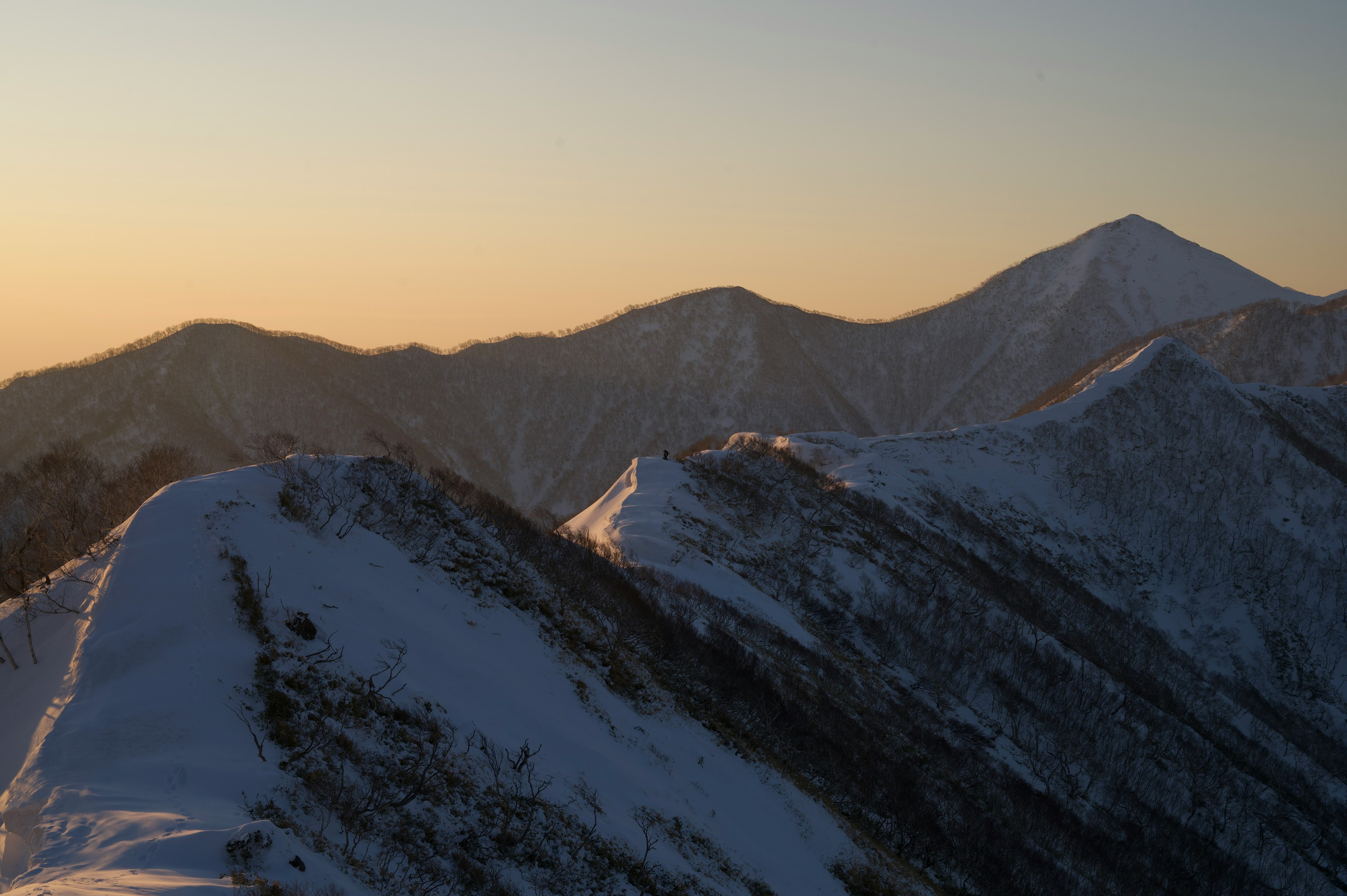 Chaîne de montagnes enneigées au coucher du soleil