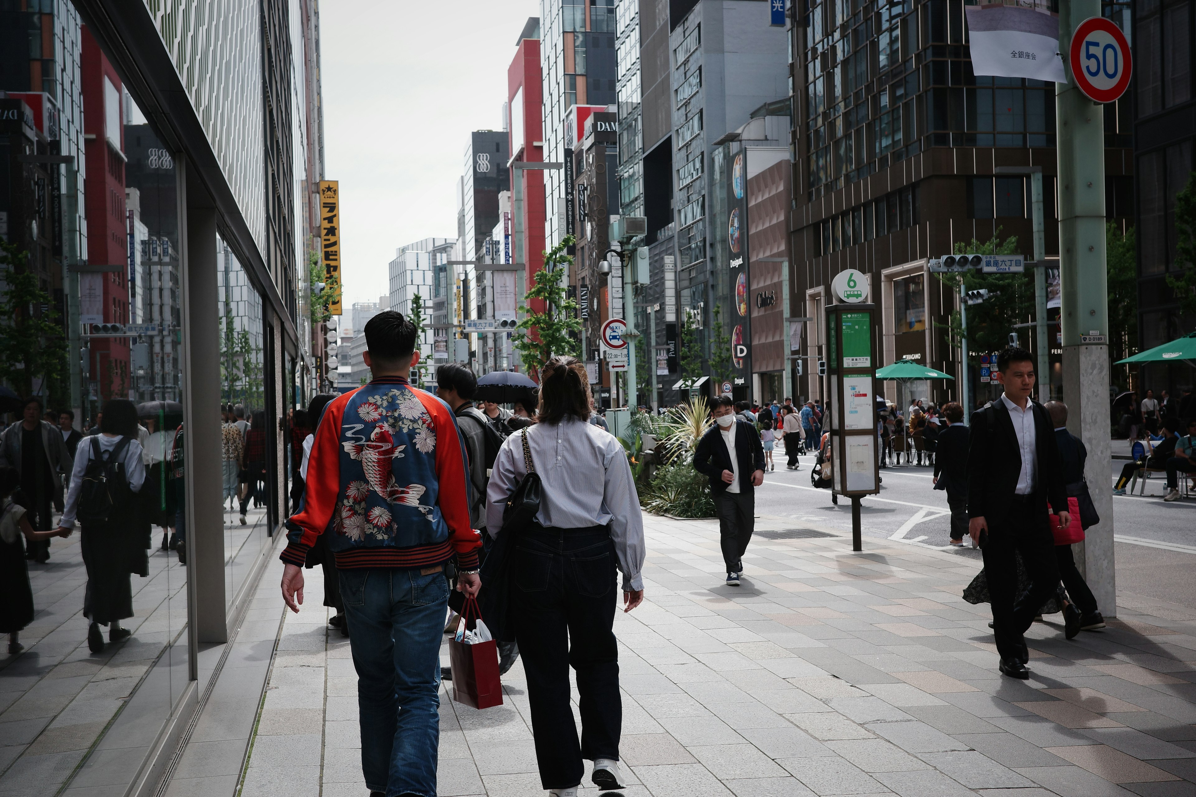 東京の繁華街を歩く人々と反射するビルの景色