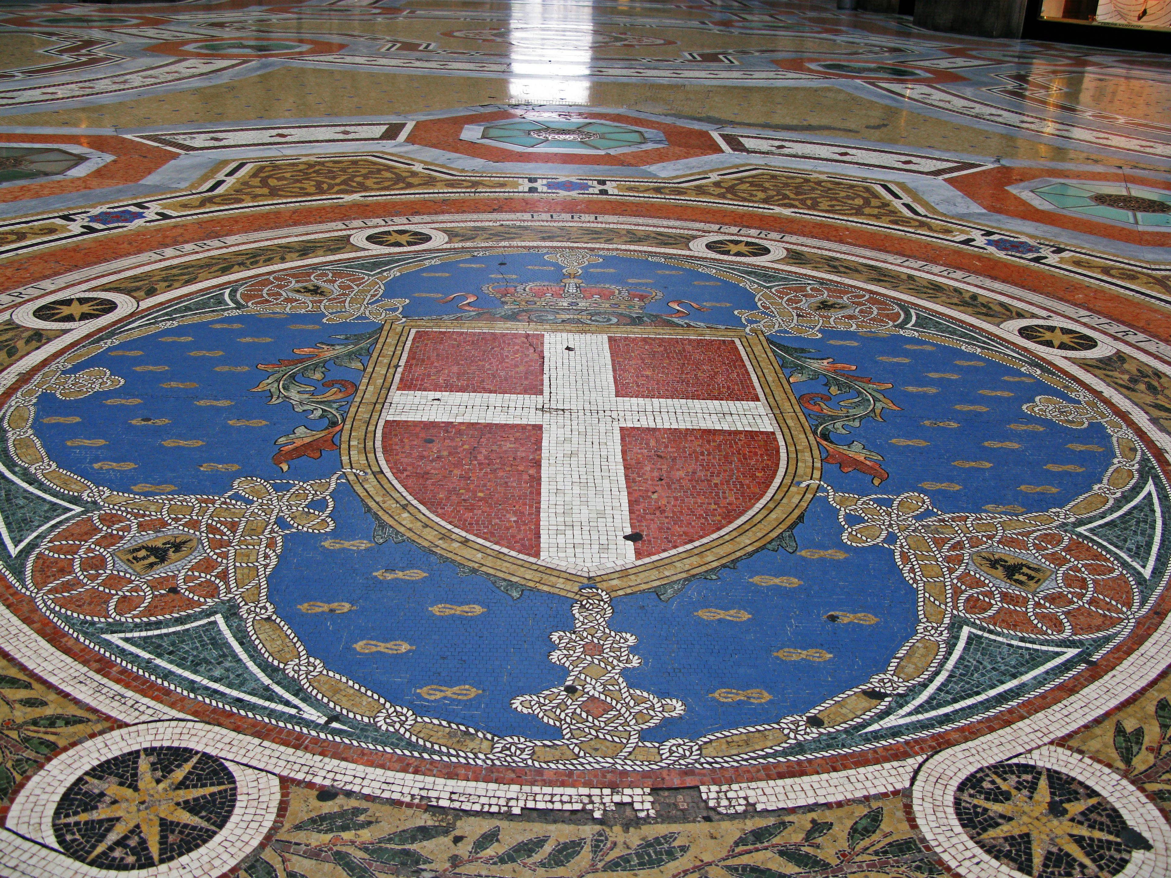 Intricate mosaic floor featuring a blue shield with a white cross