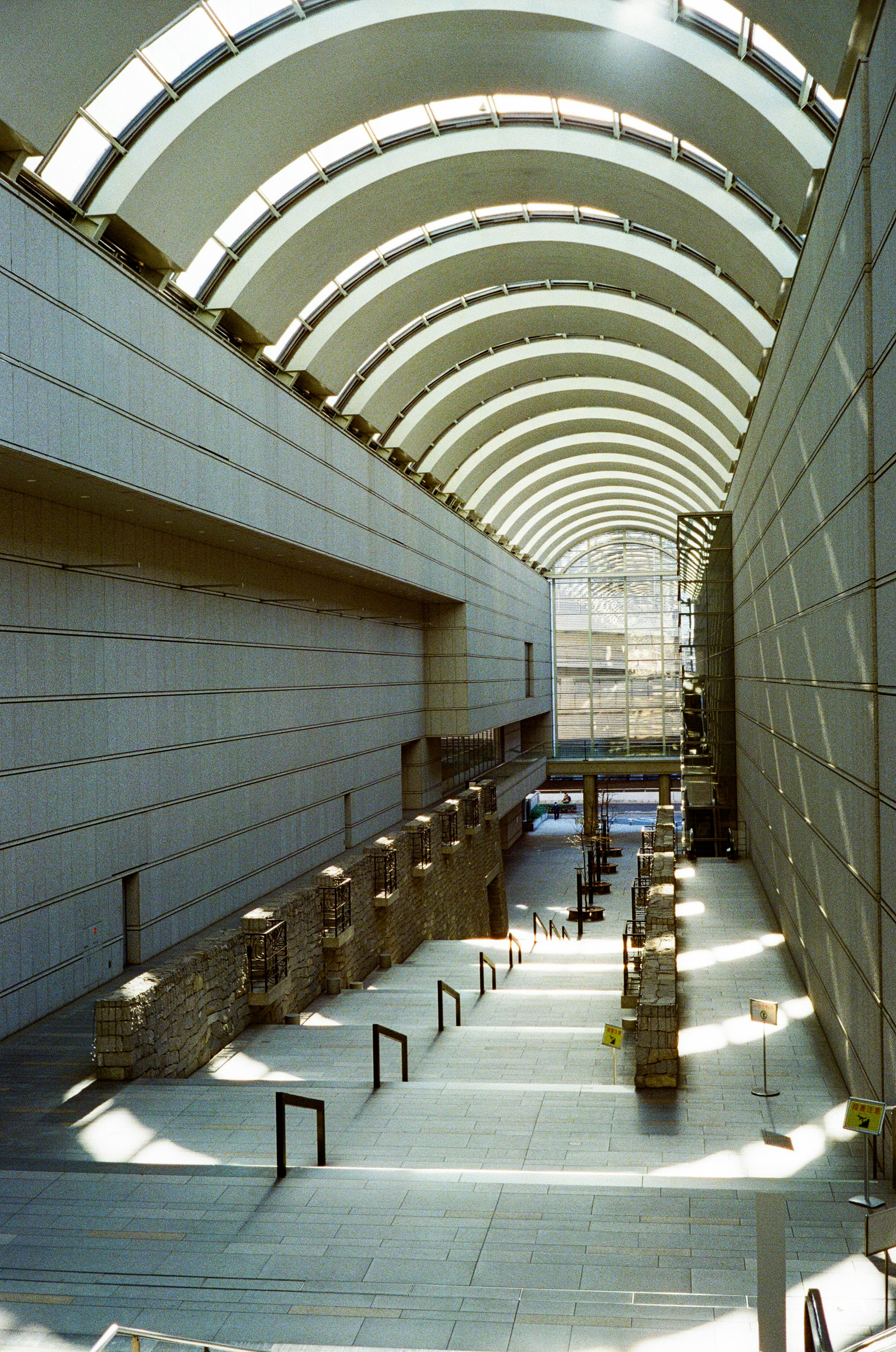 Interior of a modern art museum with arching ceiling and stone structures