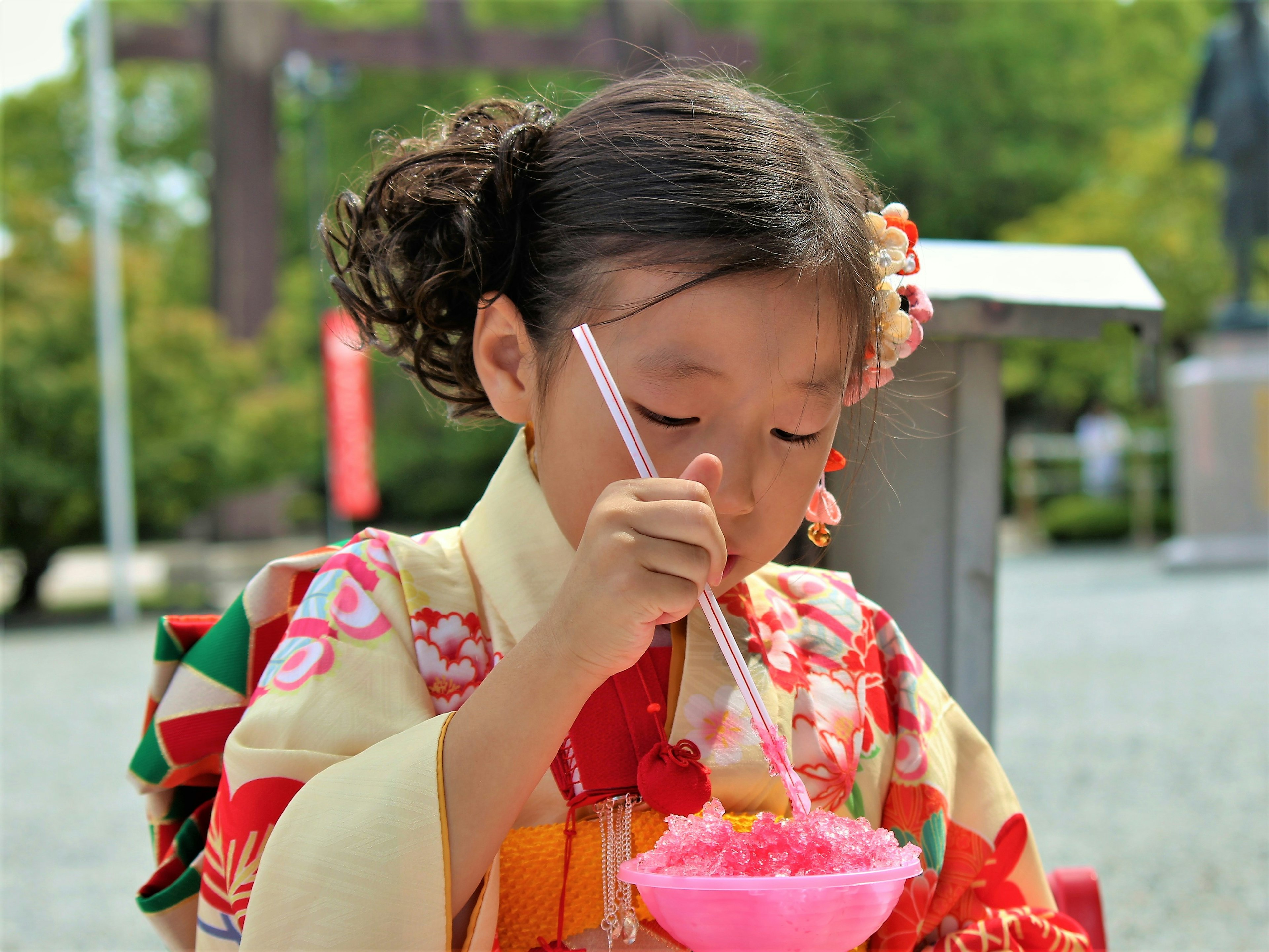 Seorang gadis berpakaian kimono menikmati es serut