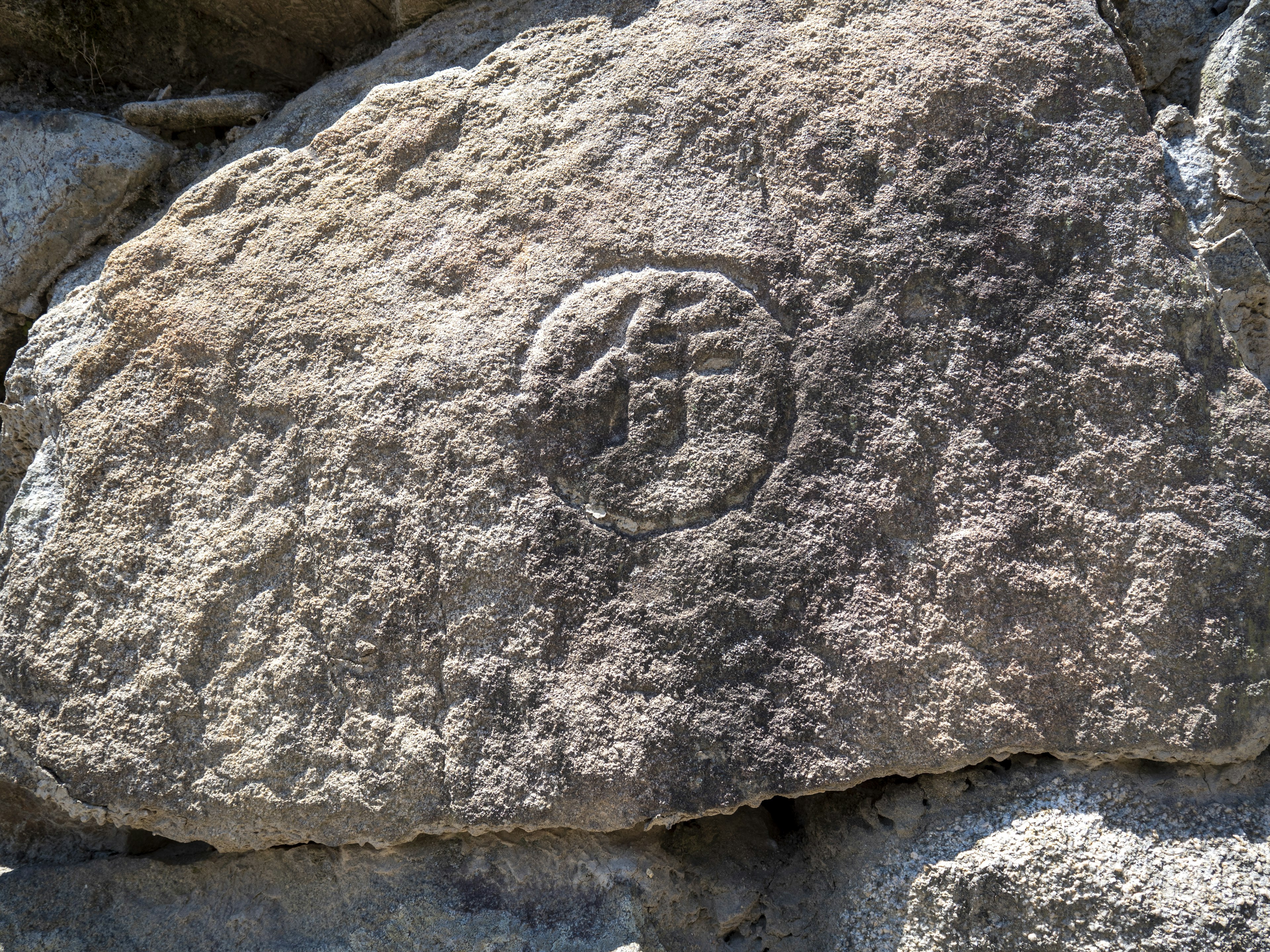 Symbole circulaire gravé sur une surface rocheuse