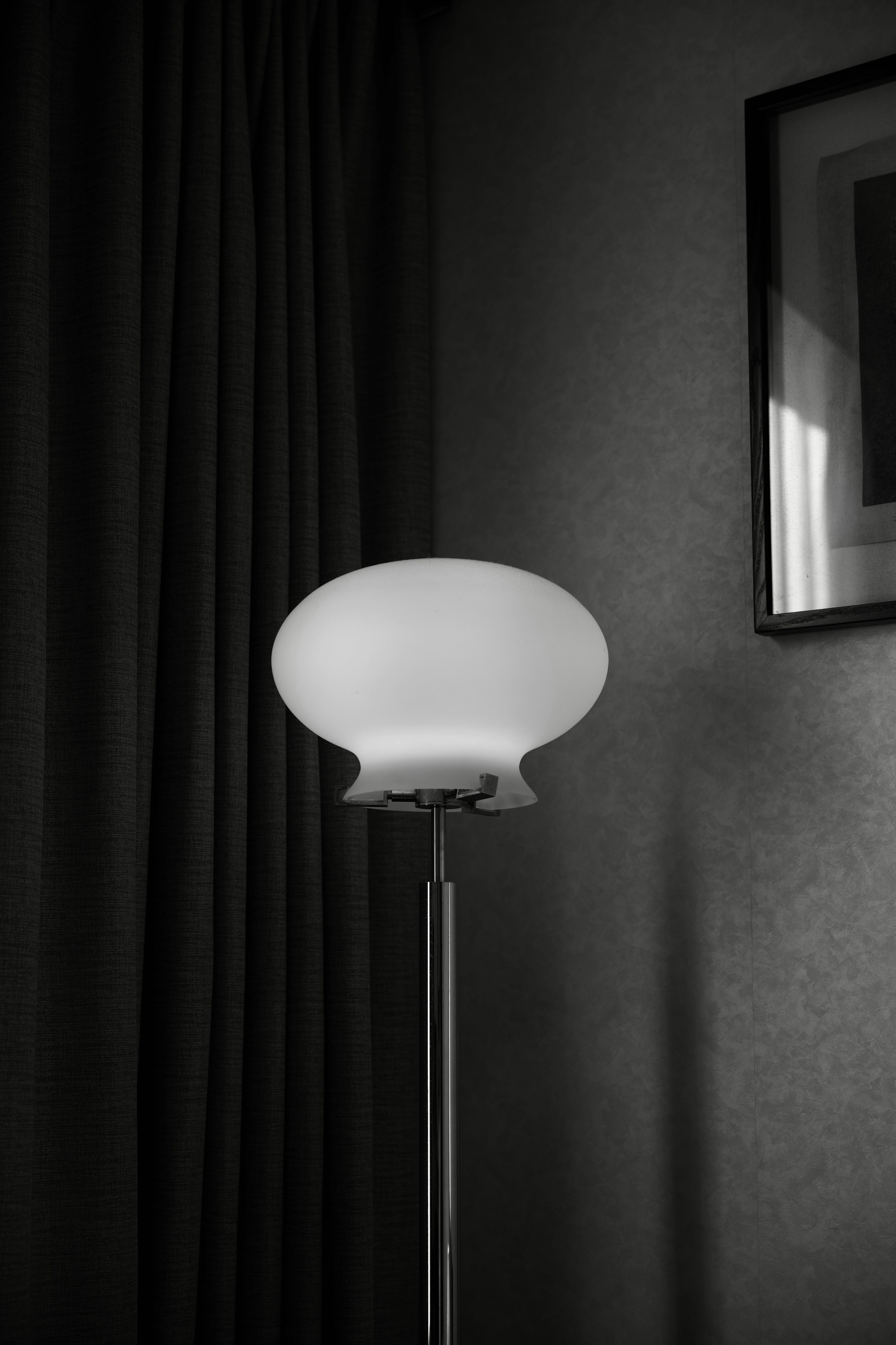 Stylish white lamp in a corner of a room with dark curtains