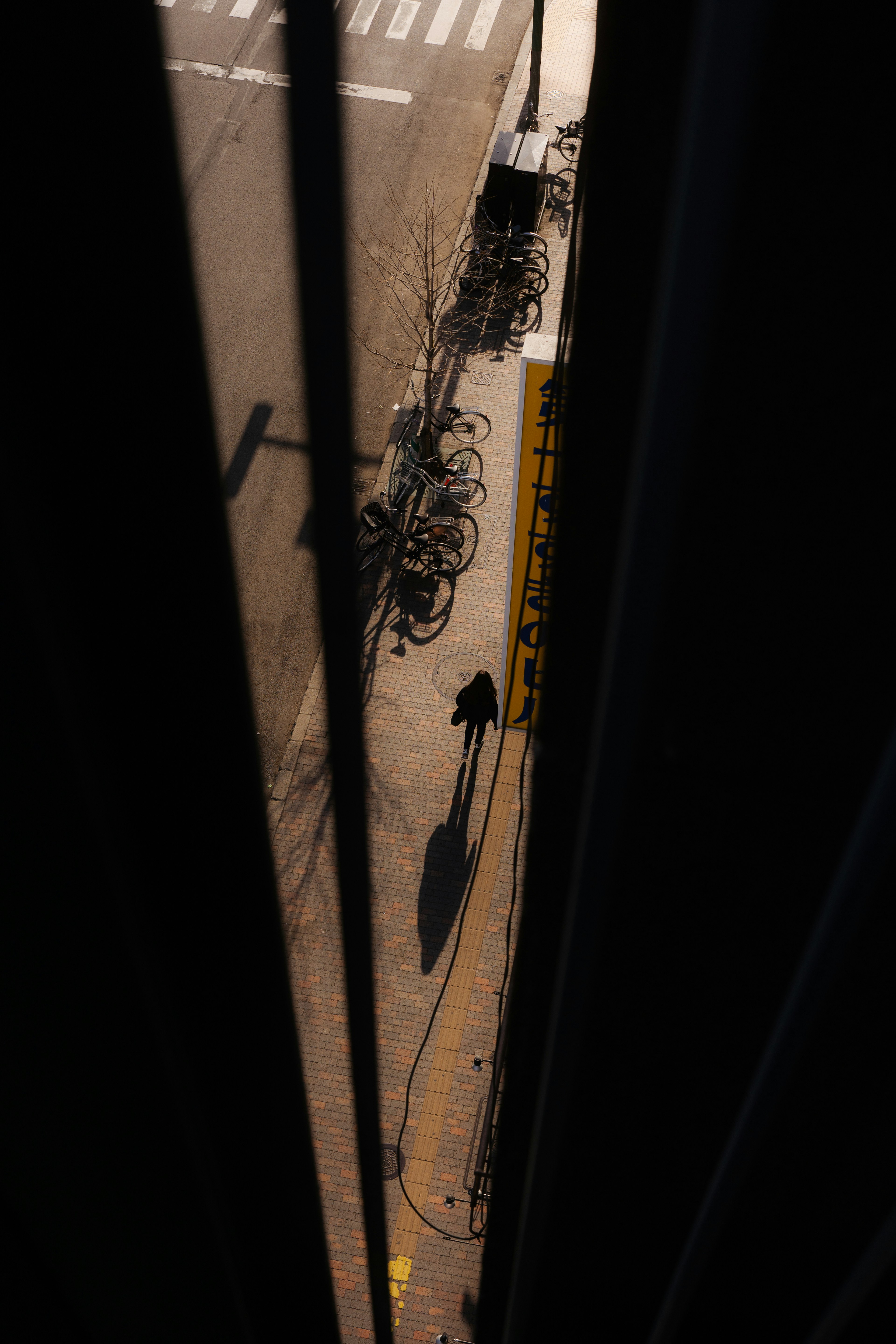 Ombre d'une personne marchant dans la rue avec des vélos alignés