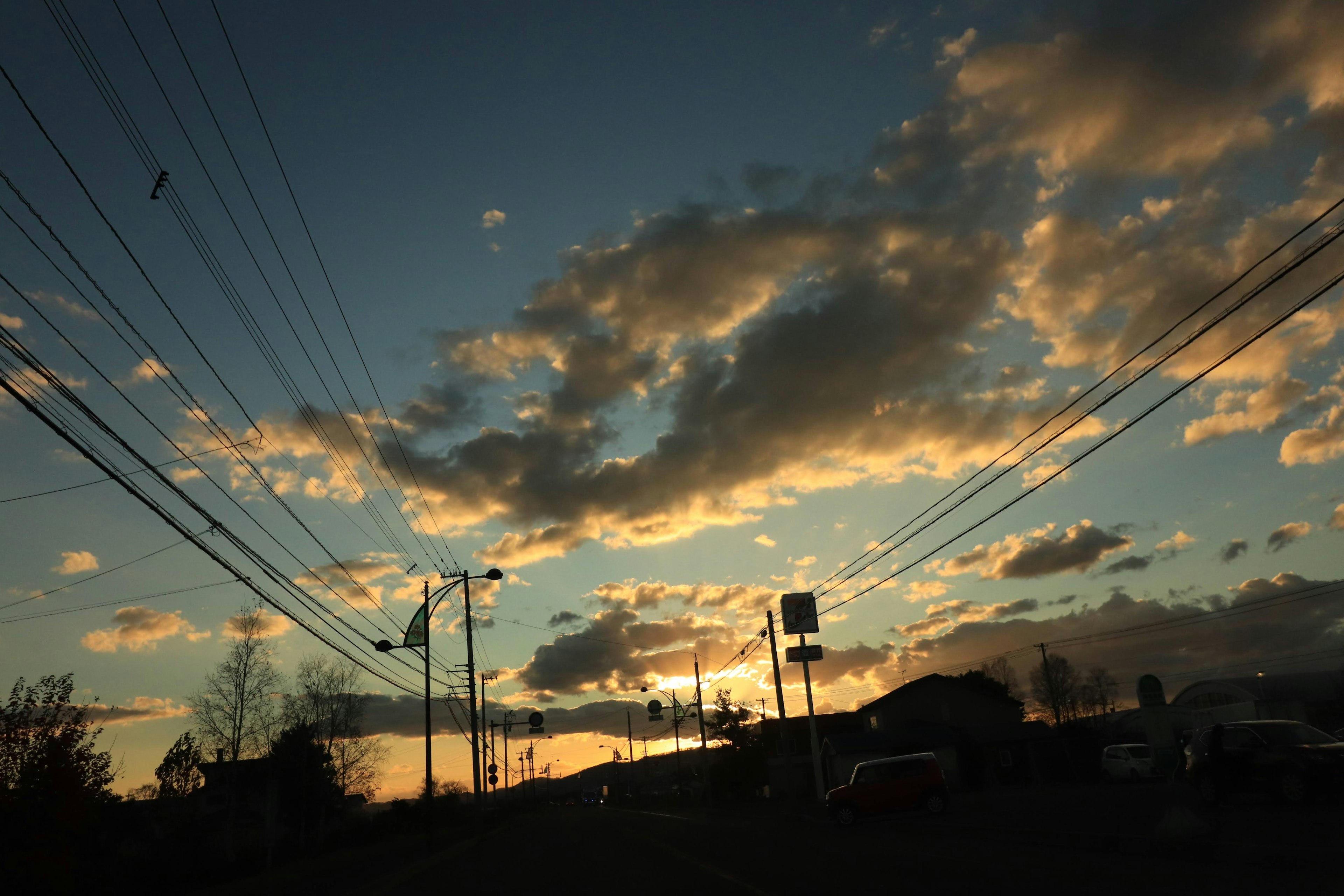 Vista escénica de un cielo al atardecer con nubes y líneas eléctricas