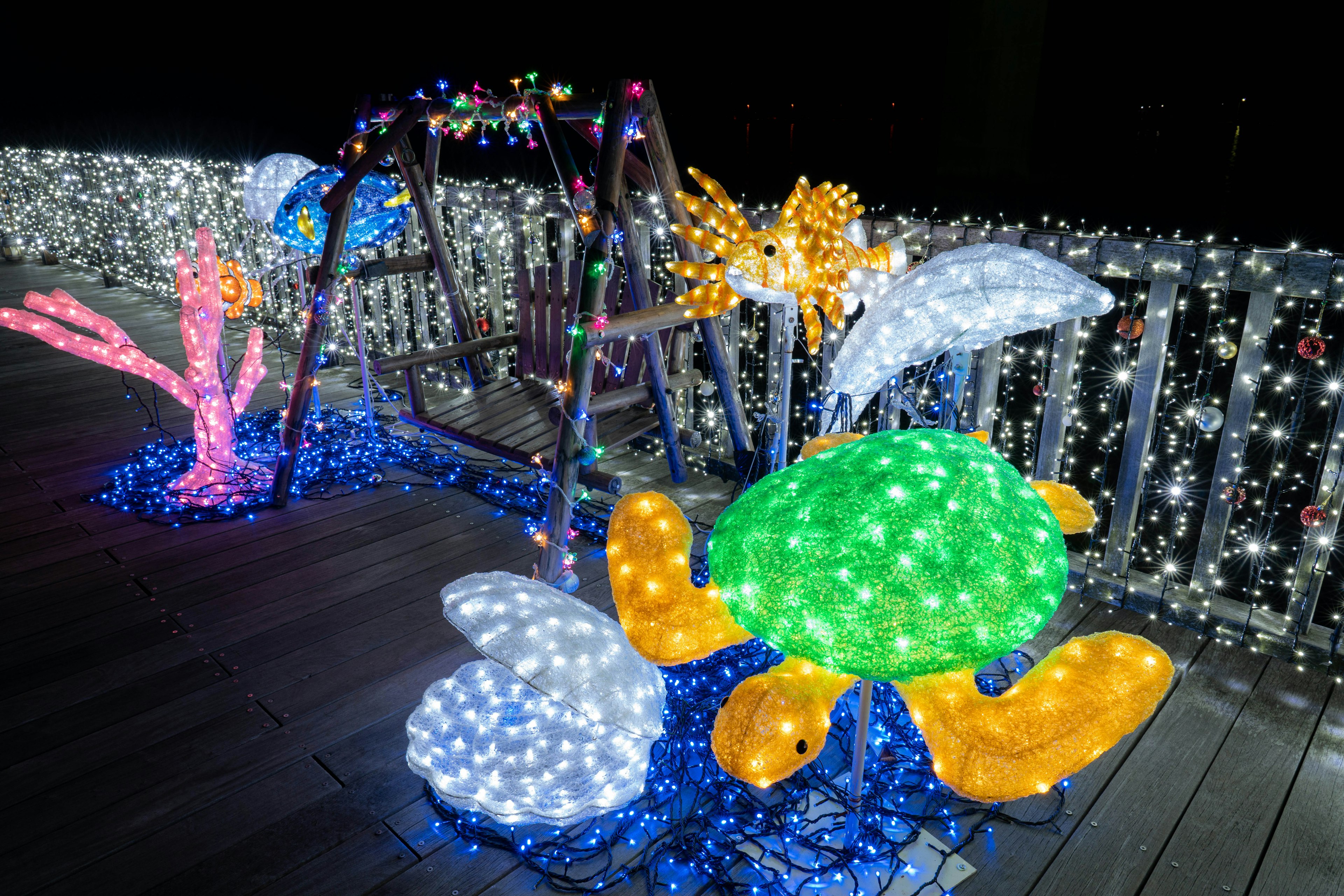 Lumières colorées décorant une balançoire et des sculptures de créatures marines