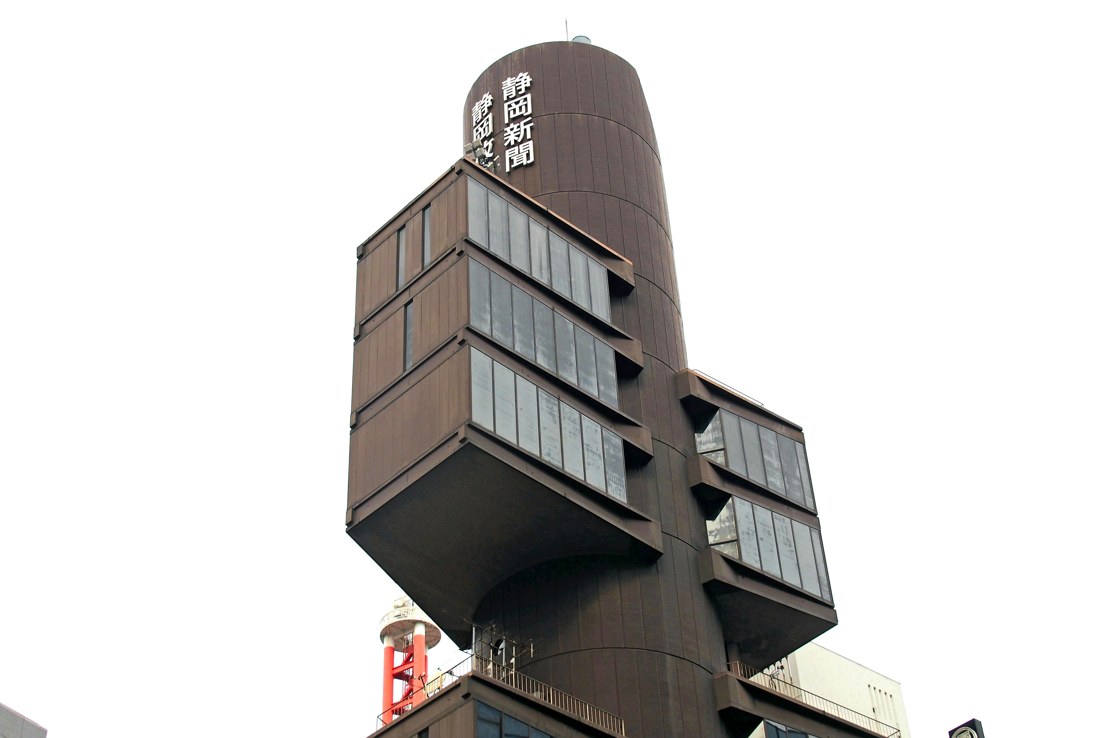 Photo of a modern building with a cylindrical top and angular windowed structure below