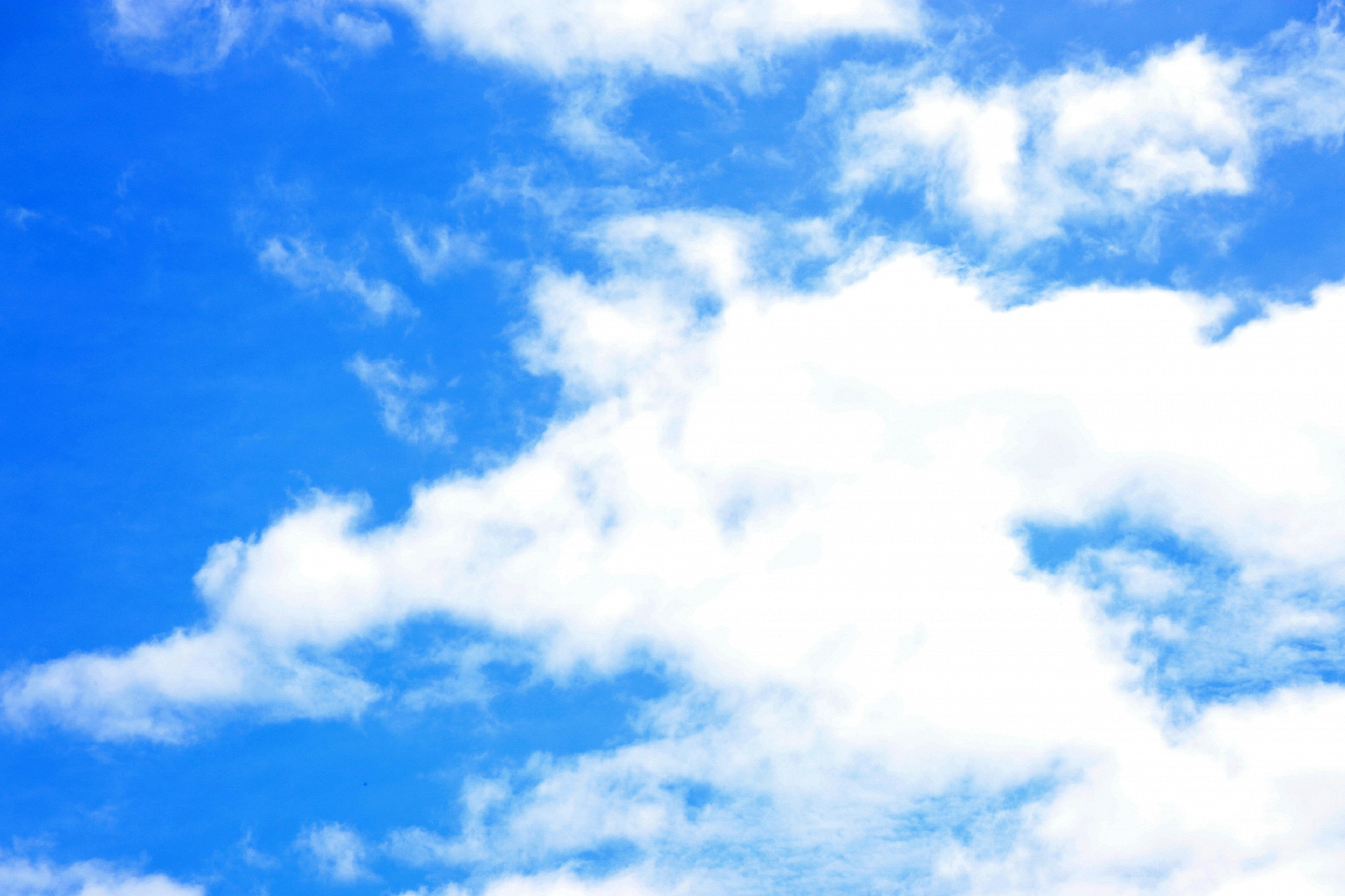 Ein heller blauer Himmel mit fluffigen weißen Wolken