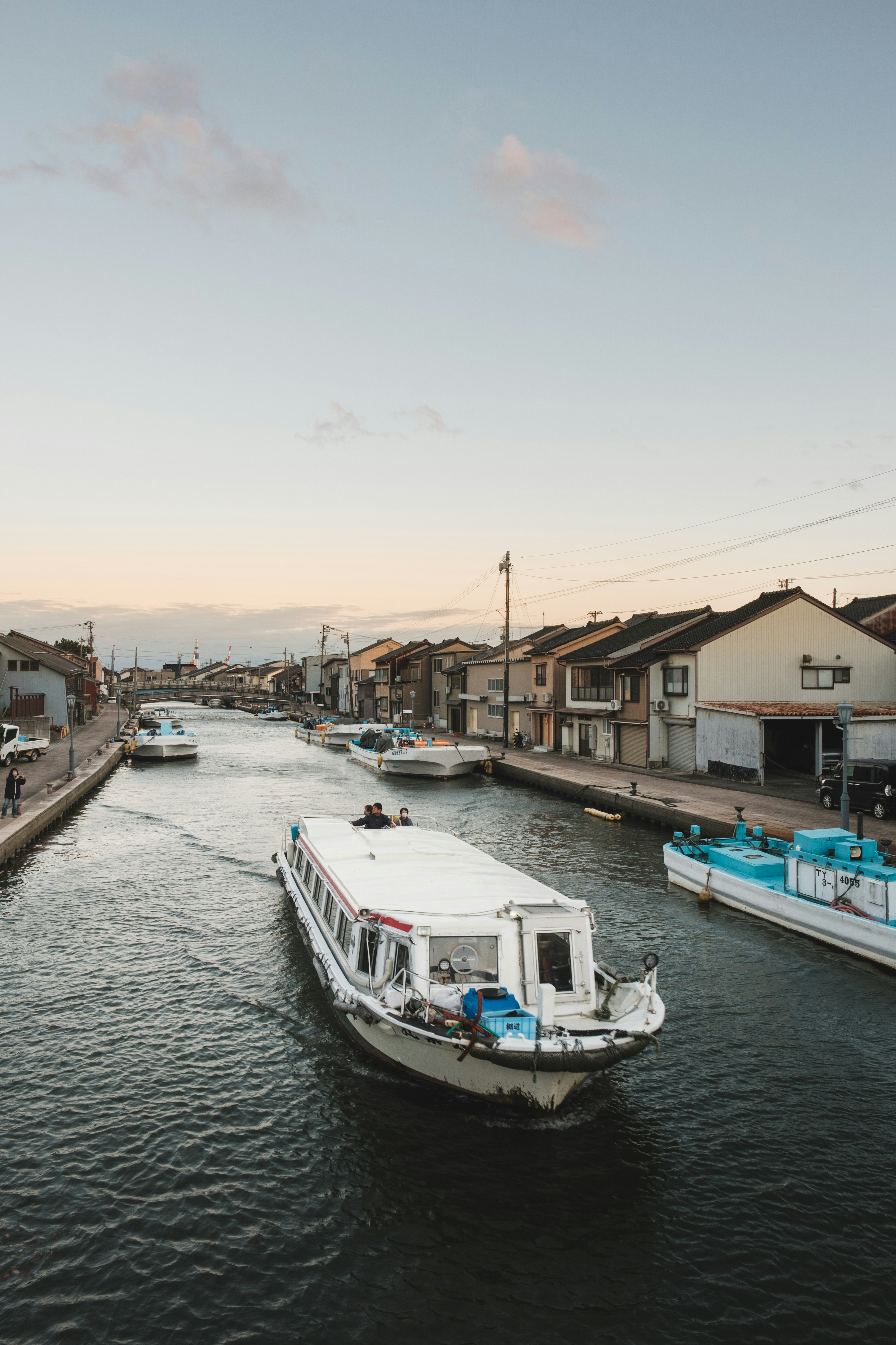 運河を進む白いボートと周囲の建物の風景