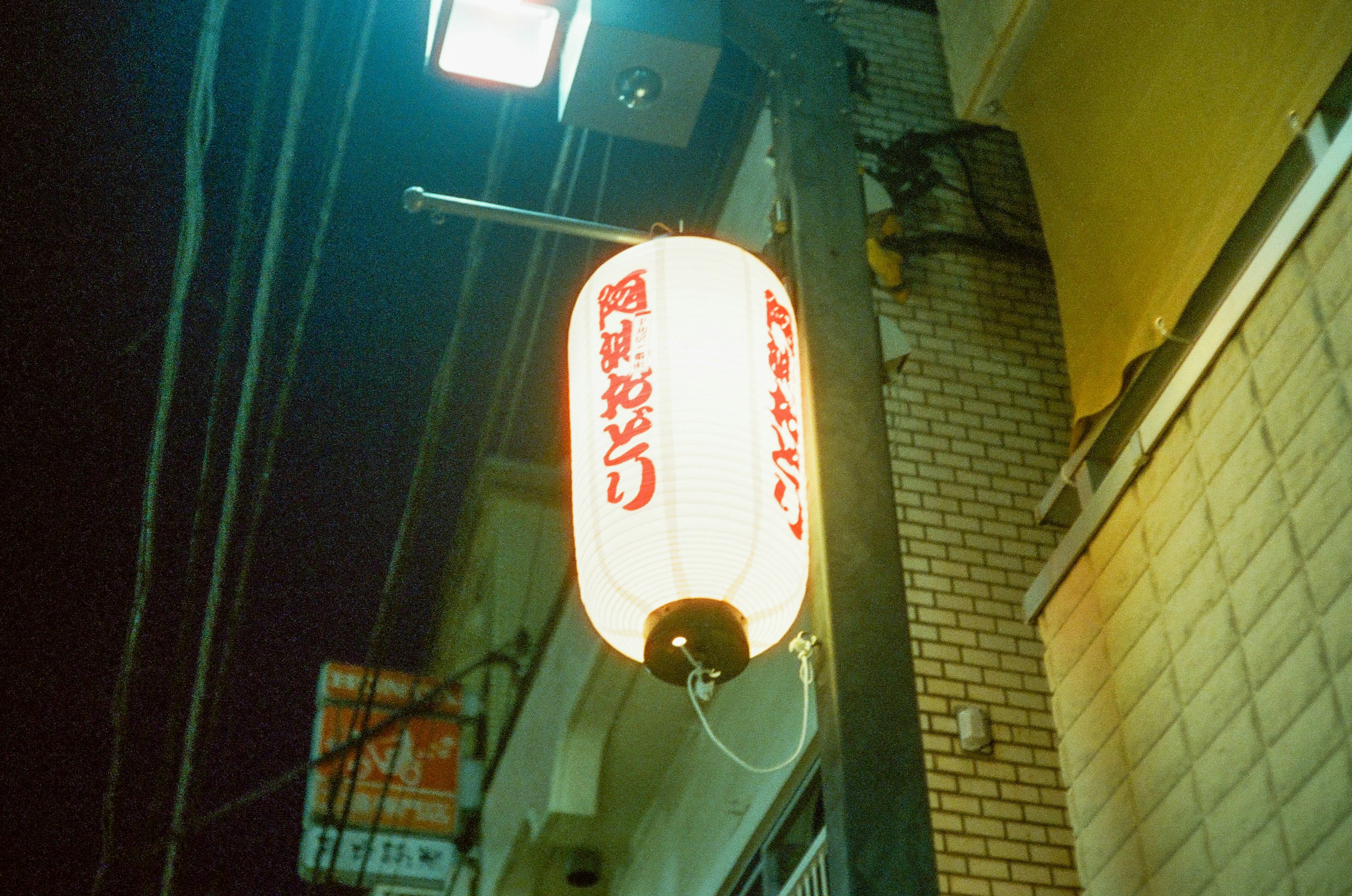 Linterna roja con caracteres japoneses colgando de noche