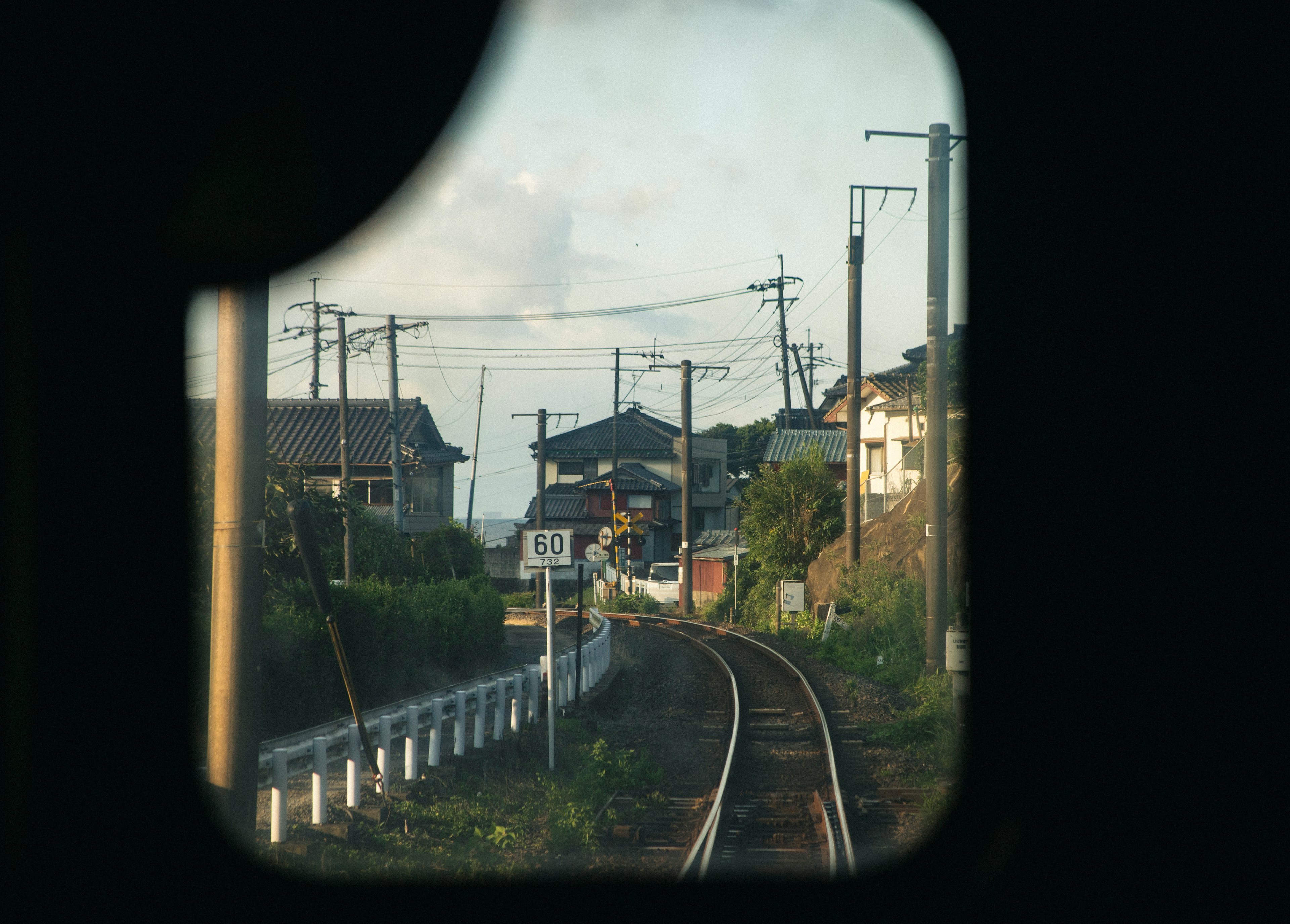 Vue des voies ferrées et des maisons à travers une fenêtre de train