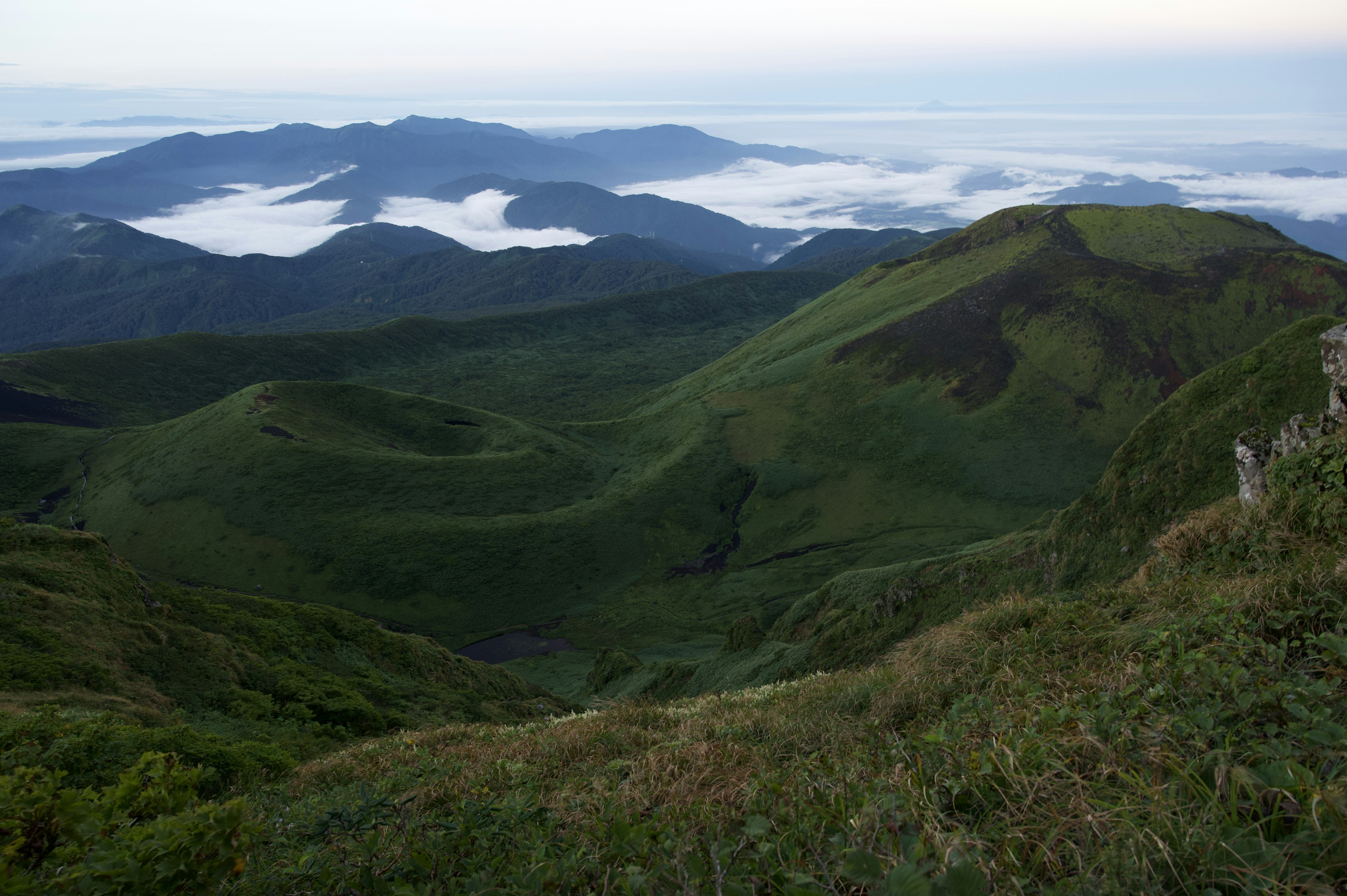 ทิวทัศน์ภูเขาสีเขียวที่มีหุบเขาที่มีหมอก