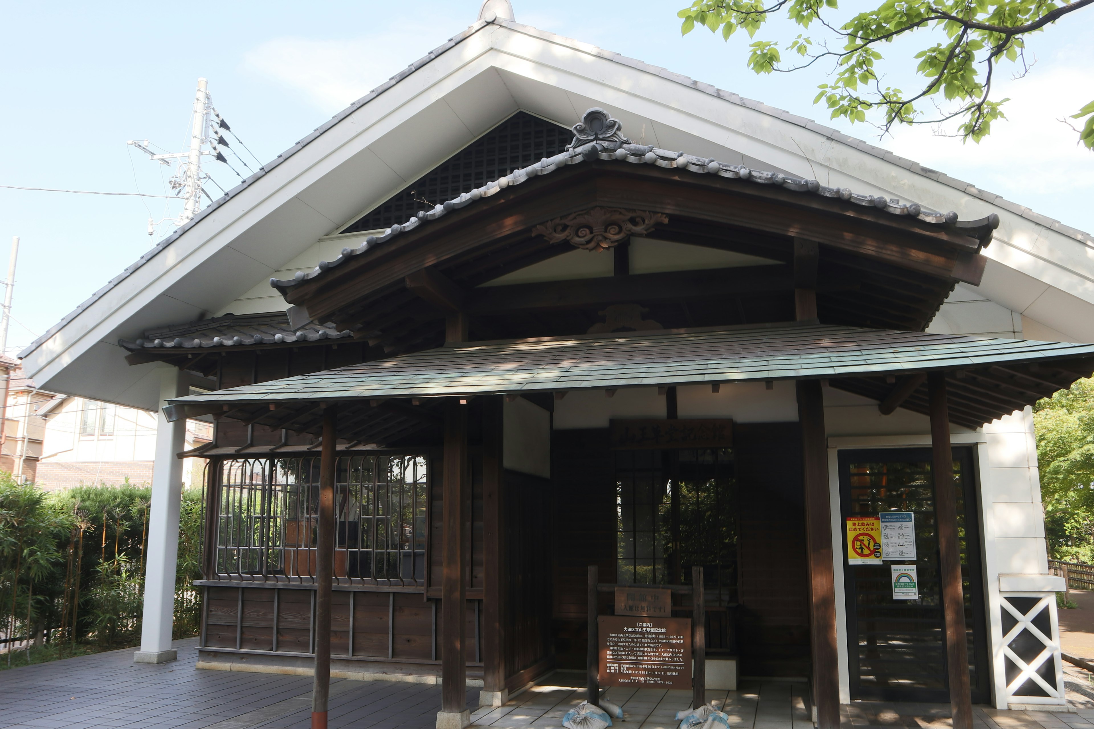 Rumah bergaya Jepang tradisional dengan atap genteng dan struktur kayu dilengkapi serambi depan