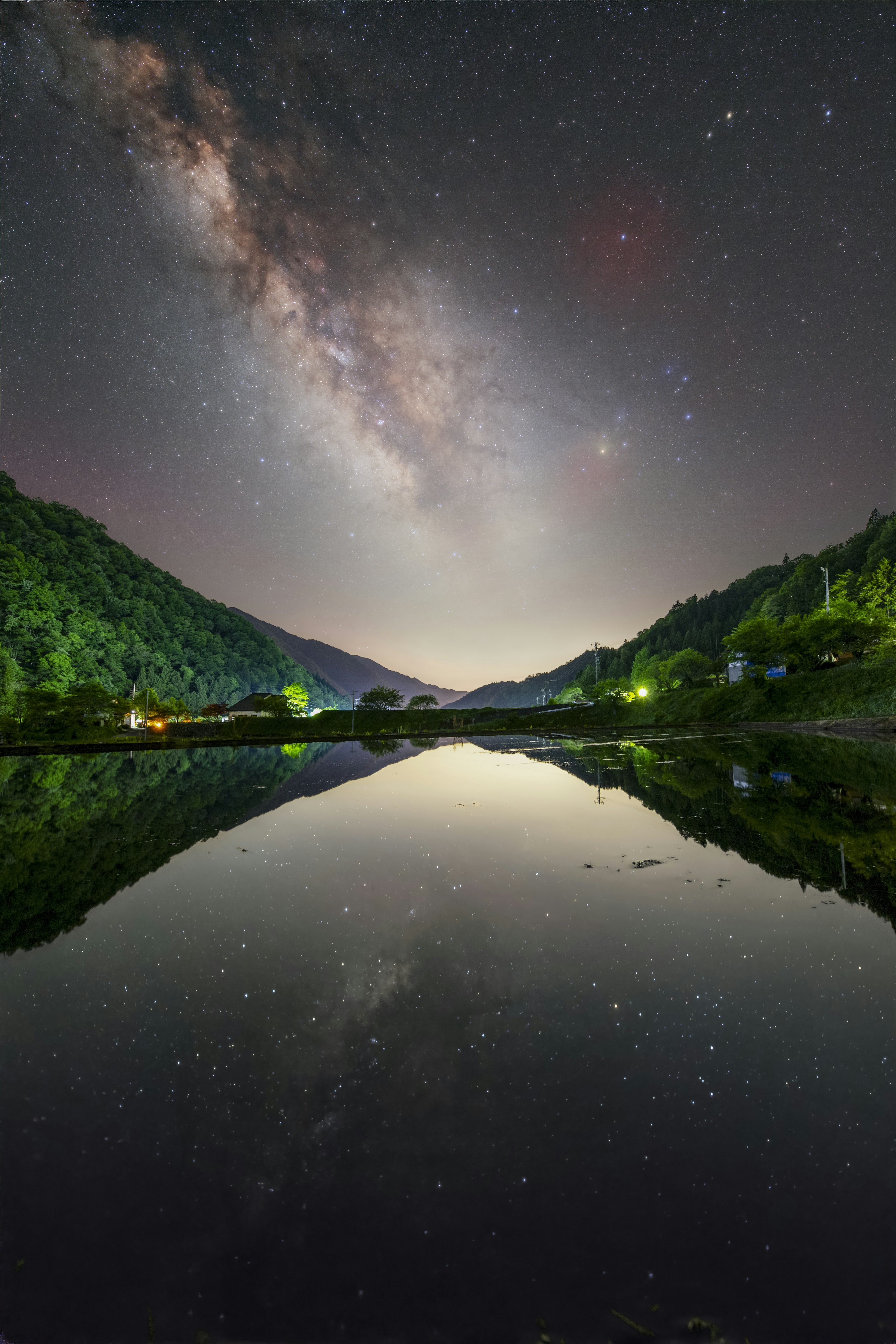 Impresionante escena nocturna con reflejos del cielo estrellado y montañas