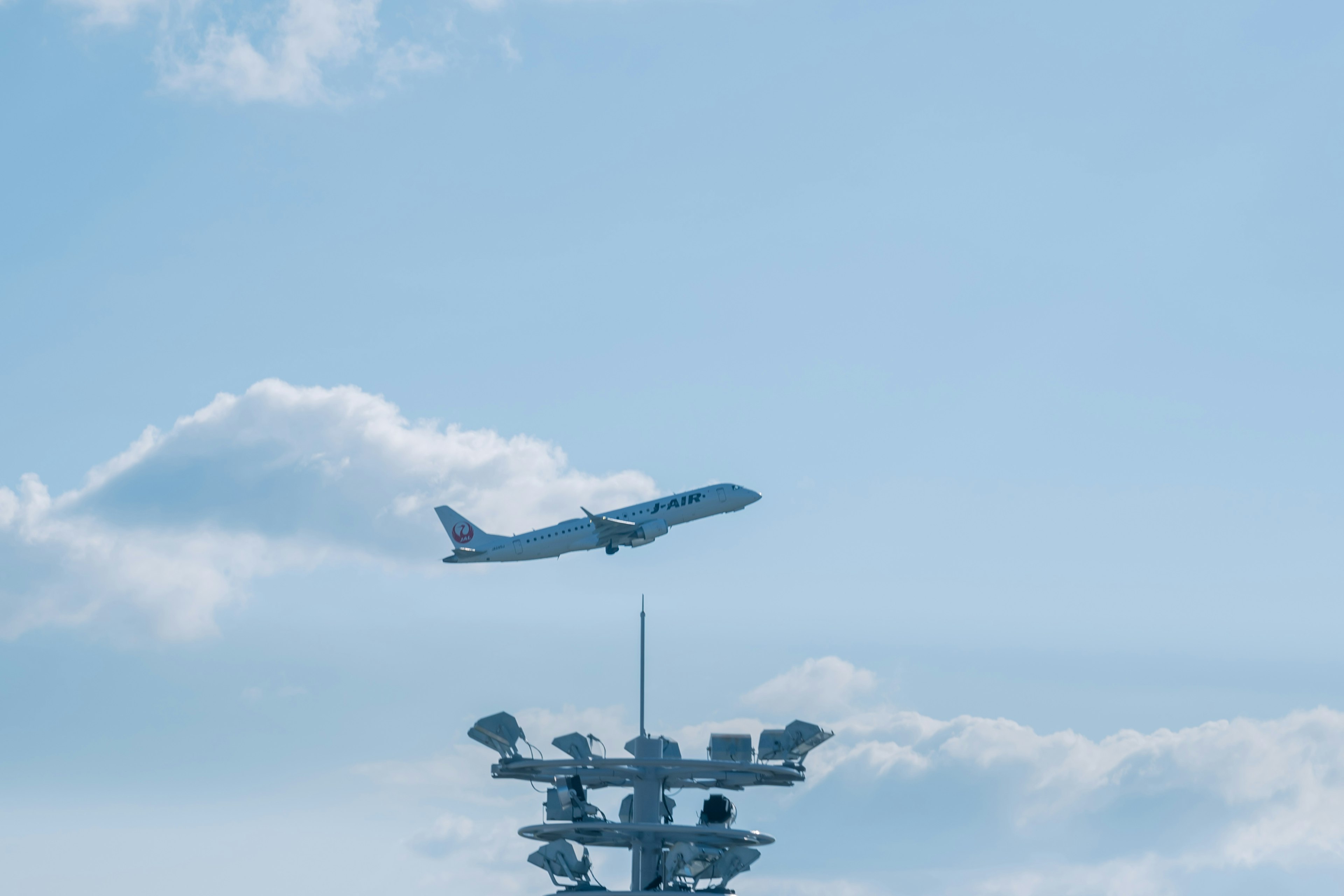 Un aereo che vola in un cielo blu con nuvole