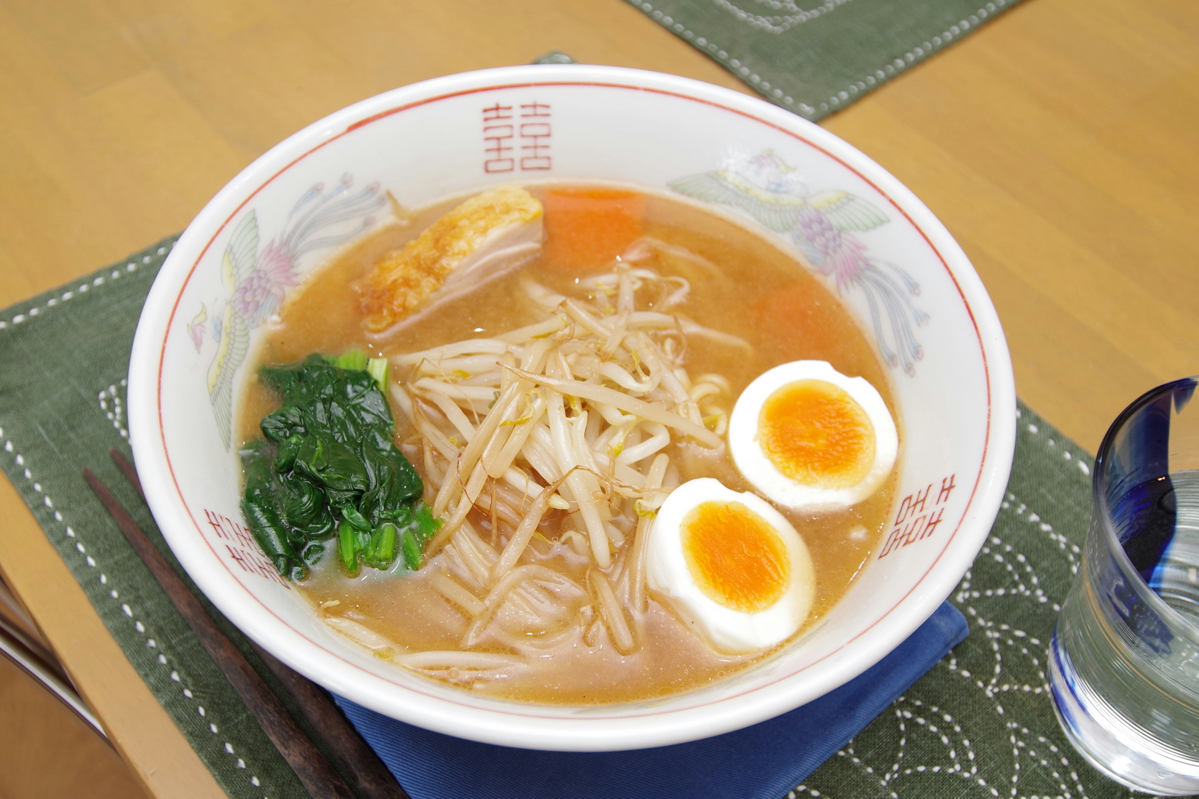 Một bát ramen có nước dùng, thịt heo thái lát, măng, trứng luộc và rau chân vịt