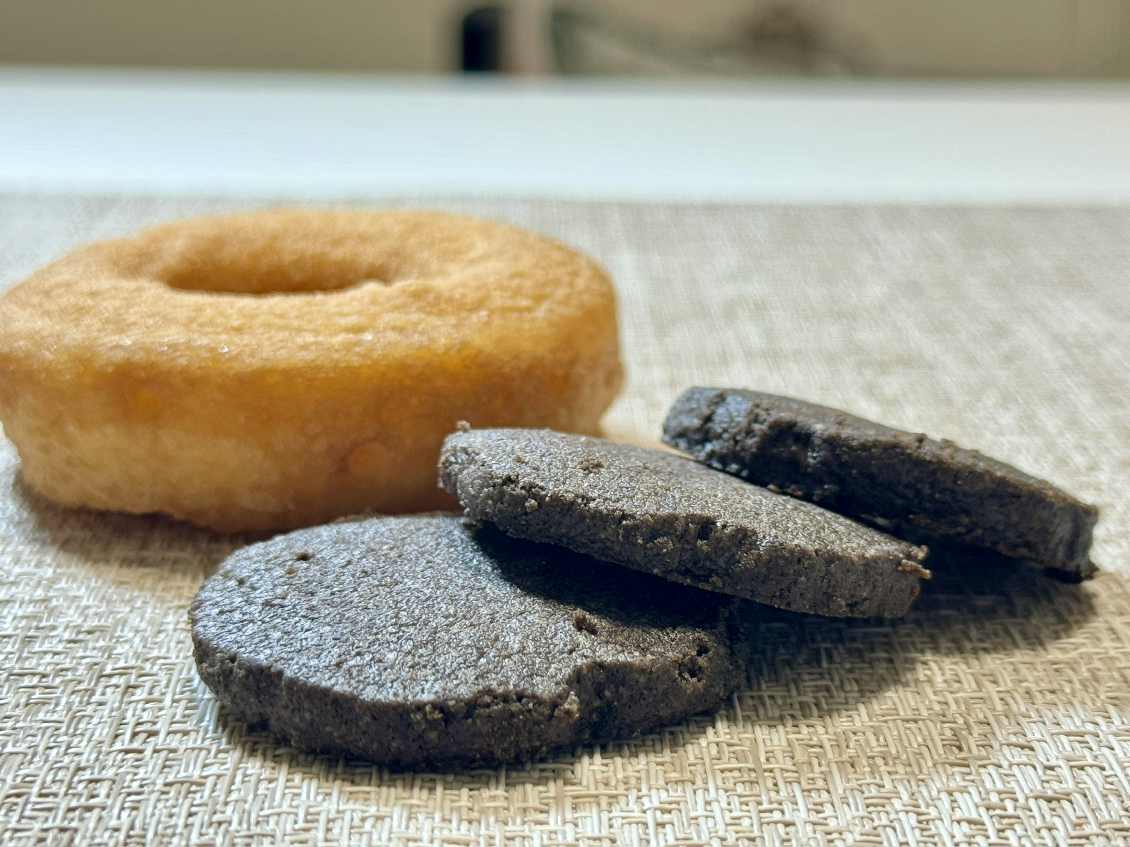 Gambar donat dan kue hitam di atas meja bertekstur