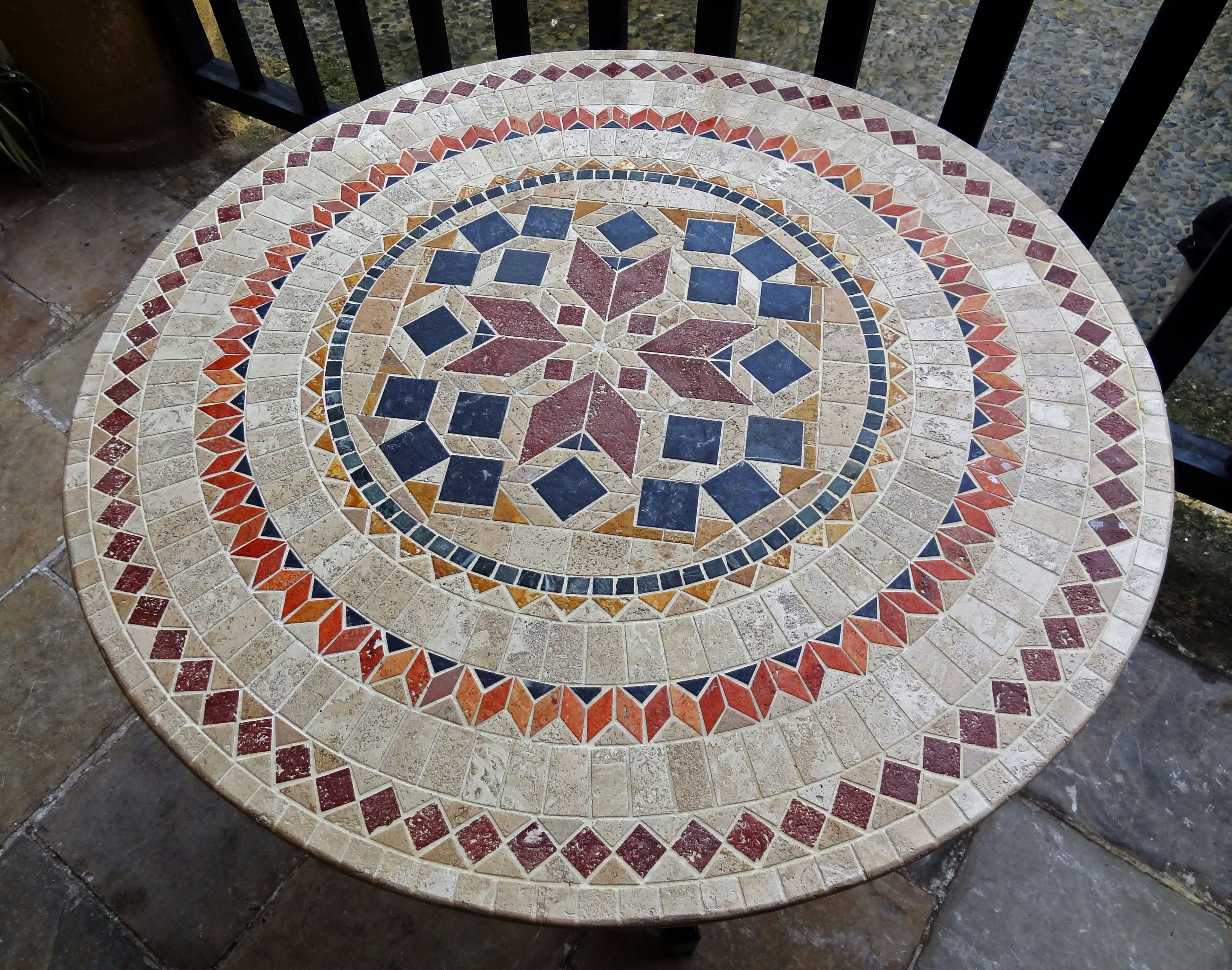 Diseño detallado de una mesa redonda de mosaico con colores vibrantes y patrones geométricos